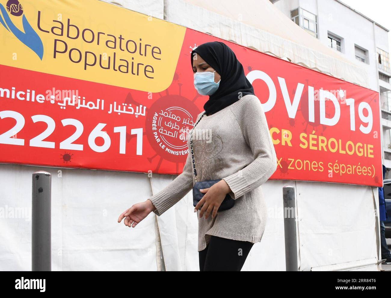 210417 -- CASABLANCA MAROCCO, 17 aprile 2021 -- Una donna che indossa una maschera cammina davanti a uno striscione di test COVID-19 a Casablanca, Marocco, il 17 aprile 2021. Il numero di casi COVID-19 del Marocco è salito a 505.447 sabato, in quanto sono stati registrati 600 nuovi casi nelle ultime 24 ore. Foto di /Xinhua MOROCCO-CASABLANCA-COVID-19-CASES Chadi PUBLICATIONxNOTxINxCHN Foto Stock