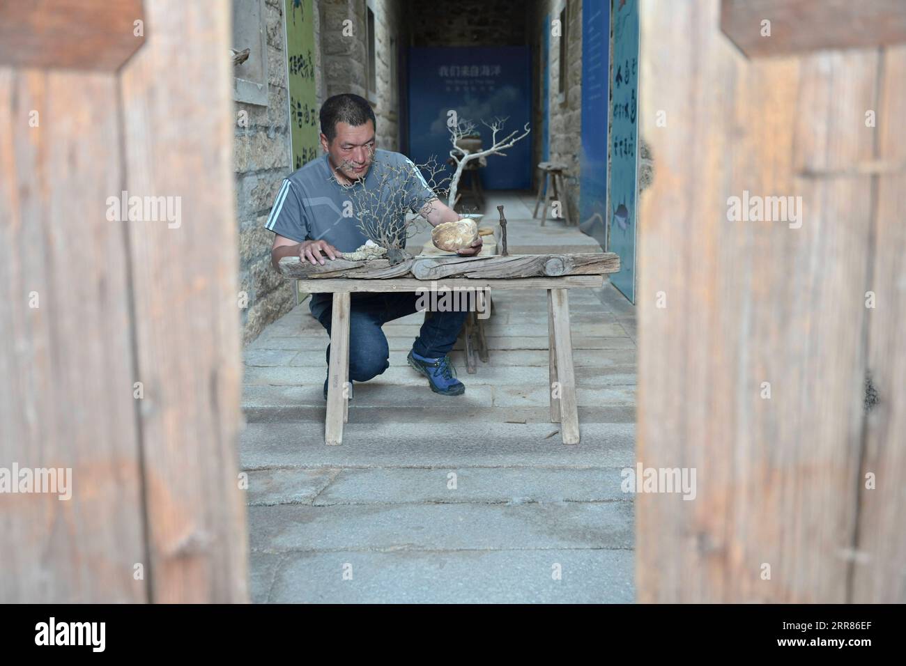 210421 -- JINJIANG, 21 aprile 2021 -- Cai Jingxiang realizza opere d'arte con i detriti delle barche, conchiglie e corallum rotto nella sua sala espositiva di gallerie marine nella città di Jinjiang, nella provincia del Fujian della Cina sud-orientale, il 19 aprile 2021. CAI Jingjiang, un designer di pubblicità di carriera, è tornato cinque anni fa nella sua città natale al Tangdong Village, Jinjing Township della città di Jinjiang. Ha trovato ispirazione dalle deriva marine che si sono gettate a riva vicino al suo villaggio, molte delle quali in forme uniche. Un giorno dopo l'altro, Cai cercò attraverso la spiaggia e portò a casa drift con potenziale artistico, e tu Foto Stock