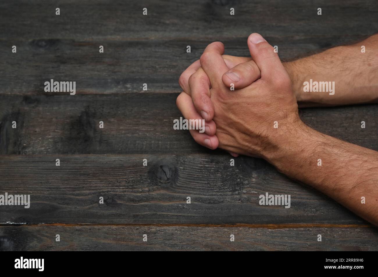 Mani maschili stringute su un tavolo di legno scuro, un'intervista difficile. primo piano Foto Stock