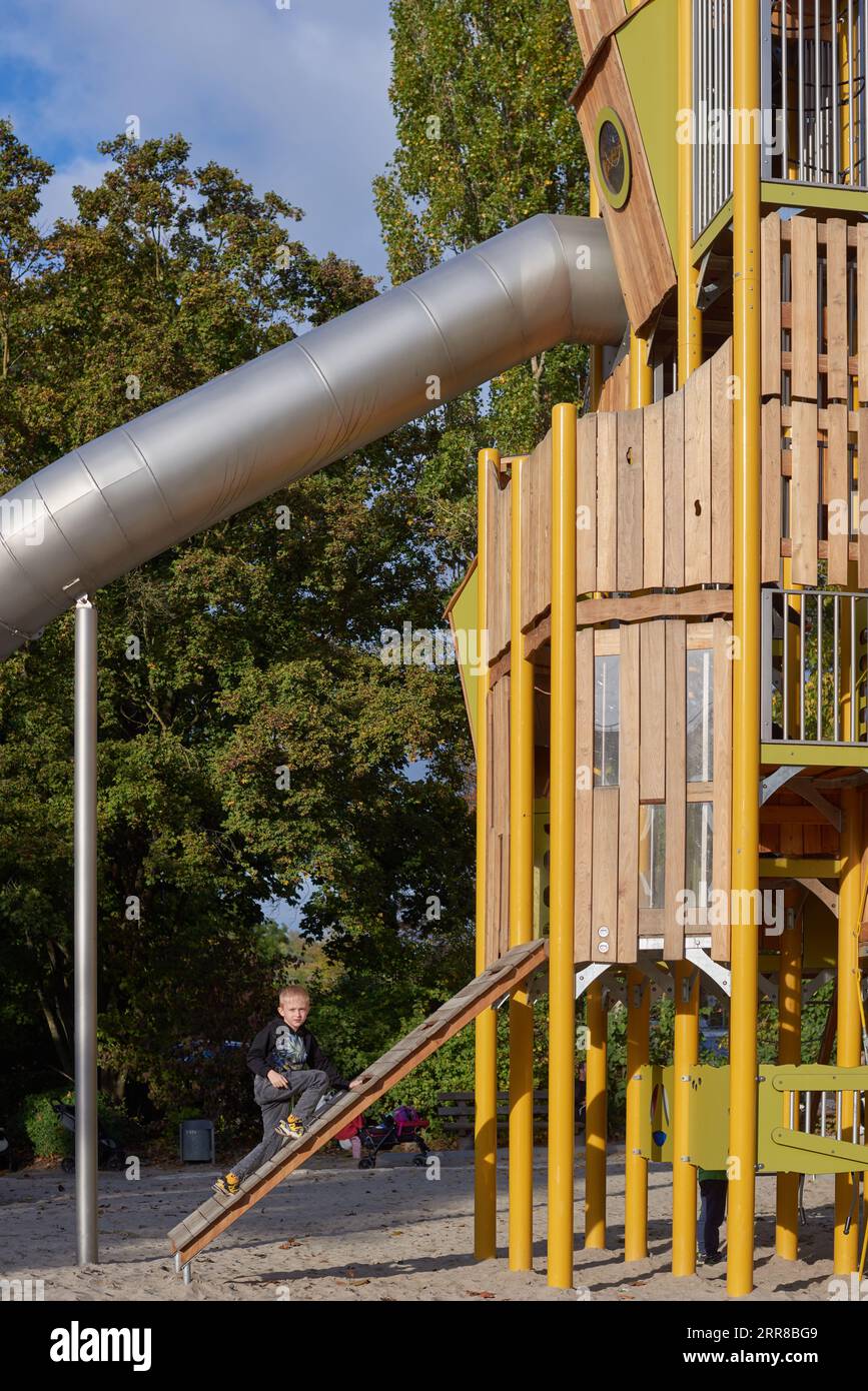 Parco giochi per bambini con scivolo moderno, ponte con rete di corda, altalene per arrampicata, arrampicatori. Parco giochi in legno vuoto realizzato in materiali ecologici - tronco di legno. Foto Stock