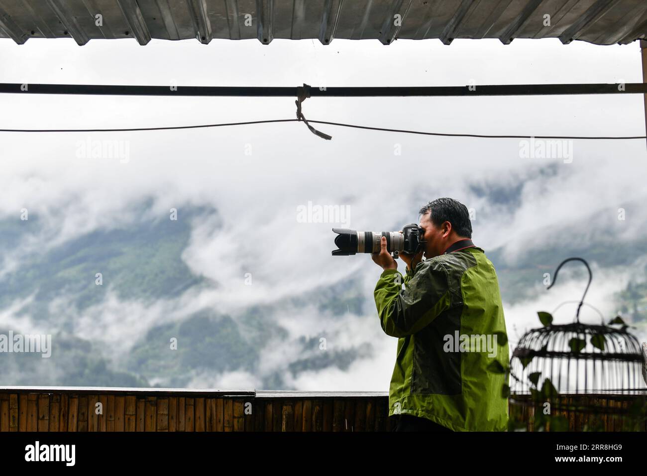 210509 -- GUIYANG, 9 maggio 2021 -- Mo Xiaoshu scatta foto dei campi terrazzati di Jiabang nella contea di Congjiang, nella provincia di Guizhou, nel sud-ovest della Cina, 4 maggio 2021. Il tempo umido persistente avvolge le terrazze con una coperta di nuvole e nebbia nella maggior parte delle mattine. Il paesaggio da sogno è quello che si può desiderare e trovare nelle foto scattate da Mo Xiaoshu. Mo, un funzionario pubblico di 39 anni, ha scattato più di 100.000 foto che registrano i campi terrazzati di Jiabang nella contea di Congjiang negli ultimi 13 anni. Il suo lavoro è diventato virale online e ha attirato bevies di cianfrusaglie per visitare le risaie a terrazze. Jiabang ha una specifica Foto Stock