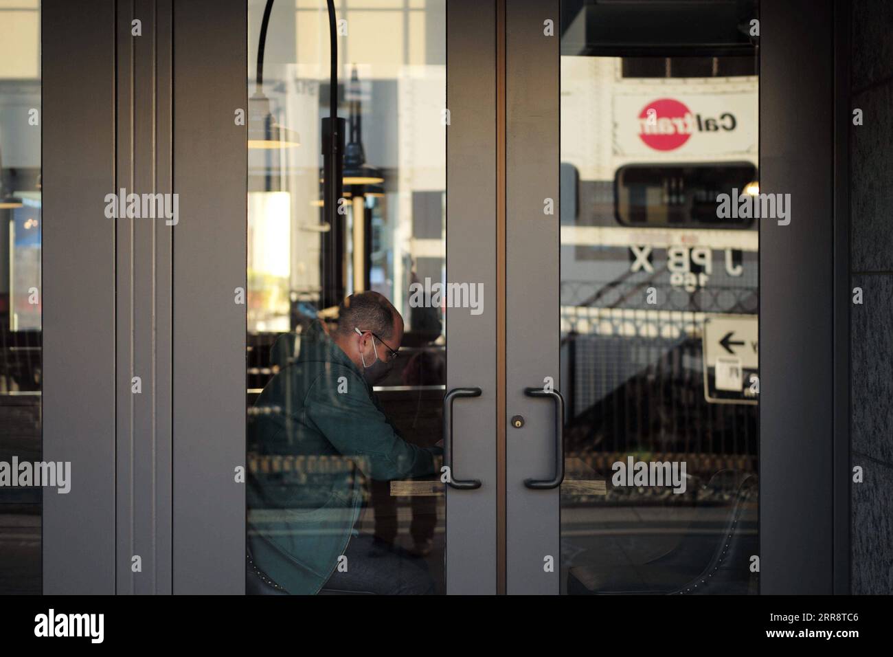 210518 -- SAN MATEO, 18 maggio 2021 -- Un cliente che indossa una maschera ordina cibo in un ristorante a San Mateo, California, Stati Uniti, 17 maggio 2021. Funzionari della sanità pubblica della California ha detto Lunedi lo stato più popoloso degli Stati Uniti non attuerebbe le linee guida CDC che consentono alle persone completamente vaccinate di andare senza una maschera nella maggior parte delle situazioni prima del 15 giugno. La scorsa settimana, i centri statunitensi per il controllo e la prevenzione delle malattie CDC ha detto la sua sicurezza per le persone completamente vaccinate per saltare le coperture facciali e il distanziamento sociale nella maggior parte delle situazioni, e molti stati hanno sollevato i loro requisiti di maschera Foto Stock