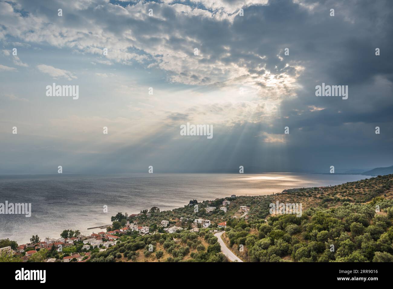 Vista panoramica del Mar Egeo contro il cielo spettacolare con i raggi del sole durante la tempesta estiva sulla costa greca Foto Stock