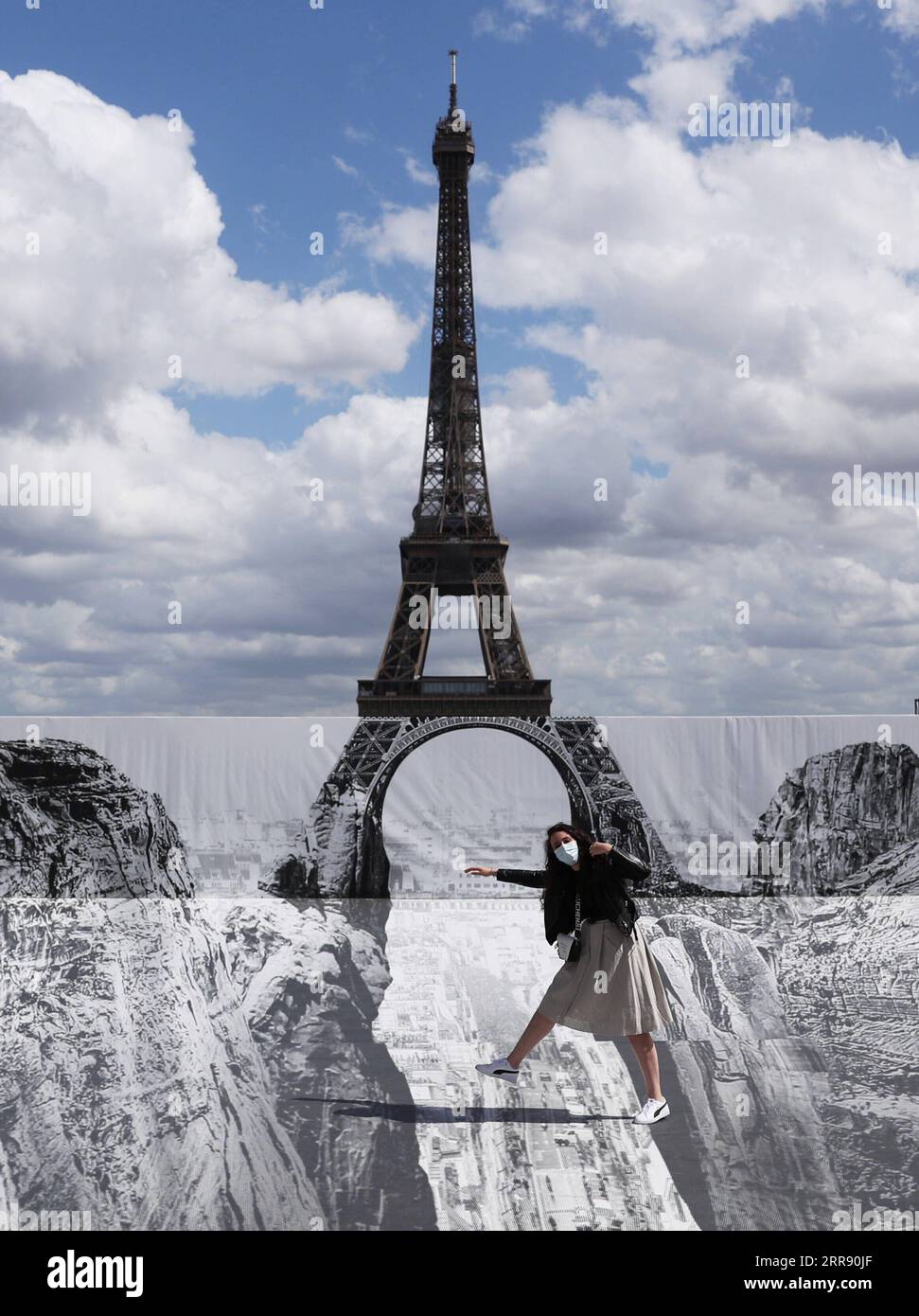 210521 -- PARIGI, 21 maggio 2021 -- Una donna posa per le foto in piazza Trocadero vicino alla Torre Eiffel, dove l'artista e fotografo francese conosciuto come JR ha allestito le sue opere, a Parigi, in Francia, il 21 maggio 2021. FRANCIA-PARIGI-TORRE EIFFEL-STREET ART GAOXJING PUBLICATIONXNOTXINXCHN Foto Stock