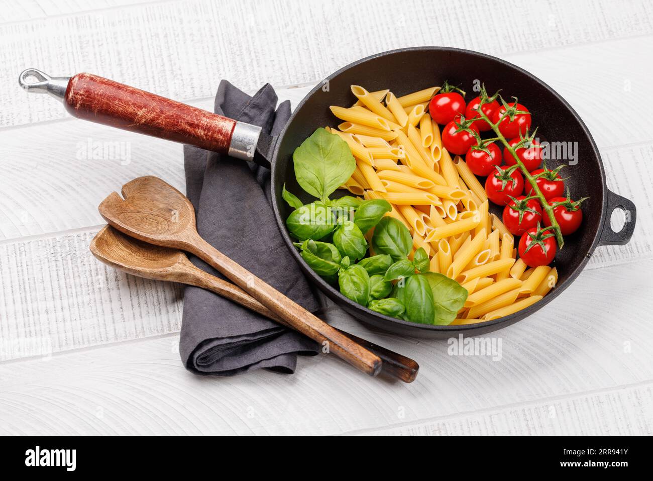 Una vivace rappresentazione della bandiera italiana fatta di pasta, basilico e pomodori, splendidamente presentata in padella Foto Stock