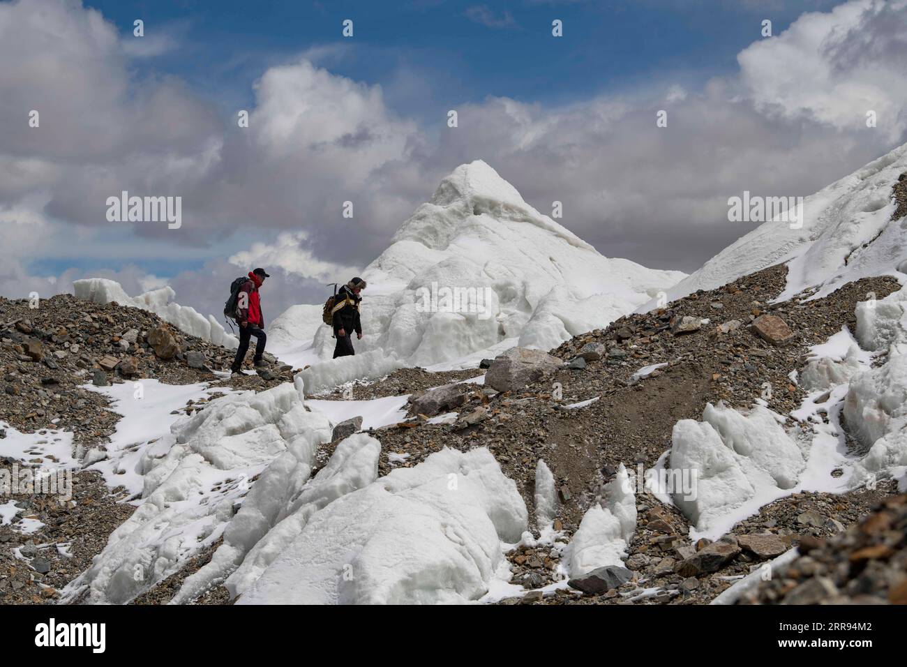 210528 -- URUMQI, 28 maggio 2021 -- Bikmirza Turdil R cammina davanti a un ghiacciaio mentre prende parte a un addestramento mirato sulla Muztagh Ata nella regione autonoma di Xinjiang Uygur della Cina nord-occidentale, 16 maggio 2021. Bikmirza, un allevatore di 24 anni, nacque e crebbe ai piedi del Muztagh Ata, un picco con un'altitudine di oltre 7.500 metri, nella regione autonoma di Uygur dello Xinjiang Pamir in Cina. Ha iniziato a lavorare come guida aiutando gli scalatori a trasportare attrezzature e provviste all'età di 18 anni. Scalare il Muztagh Ata, un simbolo di coraggio, è anche considerato come la cerimonia di raggiungimento della maggiore età per i locali Foto Stock