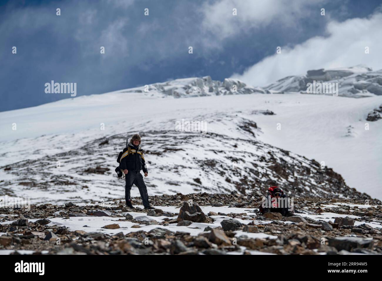 210528 -- URUMQI, 28 maggio 2021 -- Bikmirza Turdil L riposa mentre prende parte ad un addestramento mirato sulla Muztagh Ata nella regione autonoma di Xinjiang Uygur della Cina nordoccidentale, 15 maggio 2021. Bikmirza, un allevatore di 24 anni, nacque e crebbe ai piedi del Muztagh Ata, un picco con un'altitudine di oltre 7.500 metri, nella regione autonoma di Uygur dello Xinjiang Pamir in Cina. Ha iniziato a lavorare come guida aiutando gli scalatori a trasportare attrezzature e provviste all'età di 18 anni. Scalare il Muztagh Ata, un simbolo di coraggio, è anche considerato come la cerimonia di raggiungimento della maggiore età per i giovani locali. In Foto Stock
