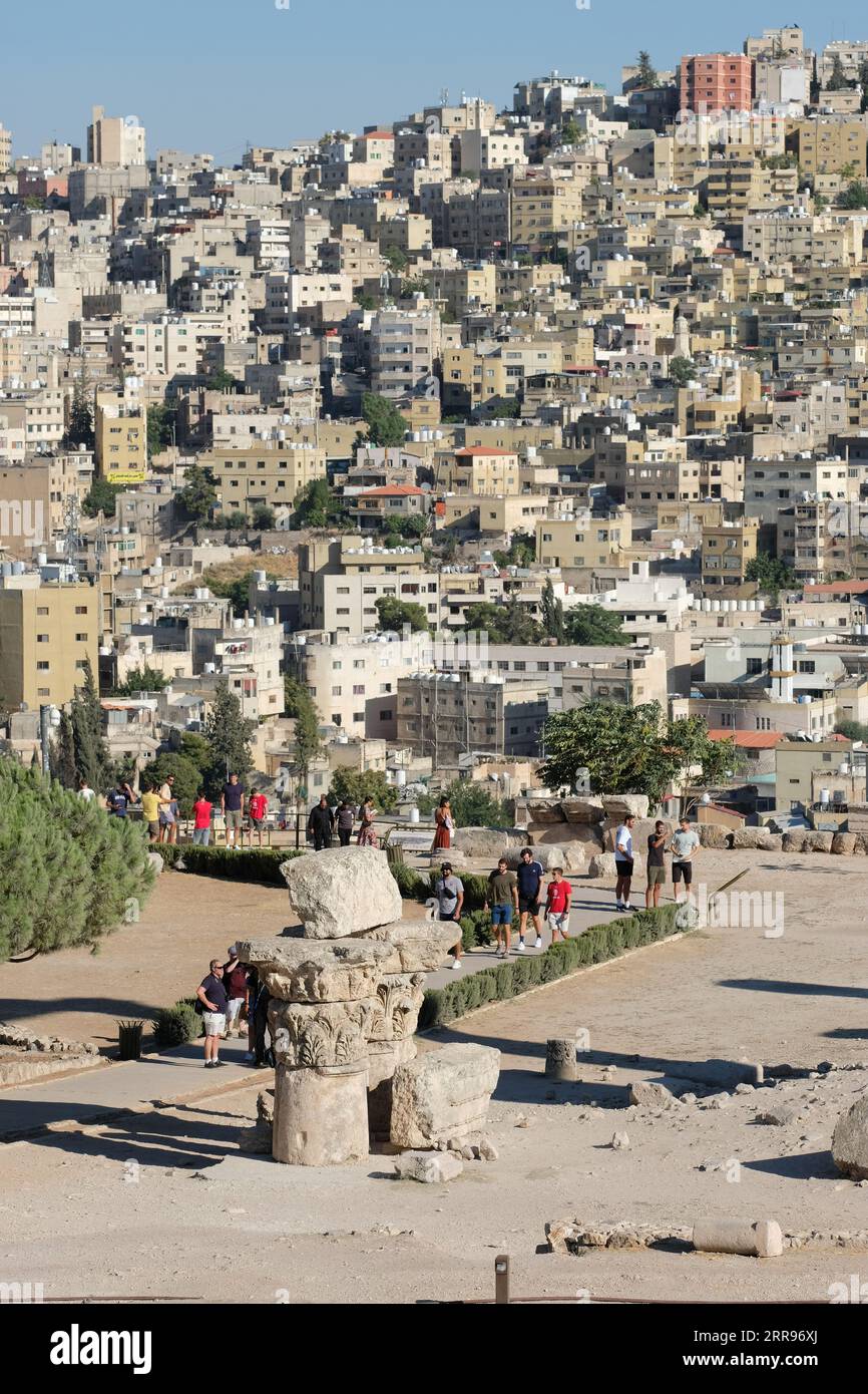 I visitatori e i turisti di Amman Giordania camminano tra le antiche rovine della Cittadella con vista sulla città capitale di Amman Foto Stock