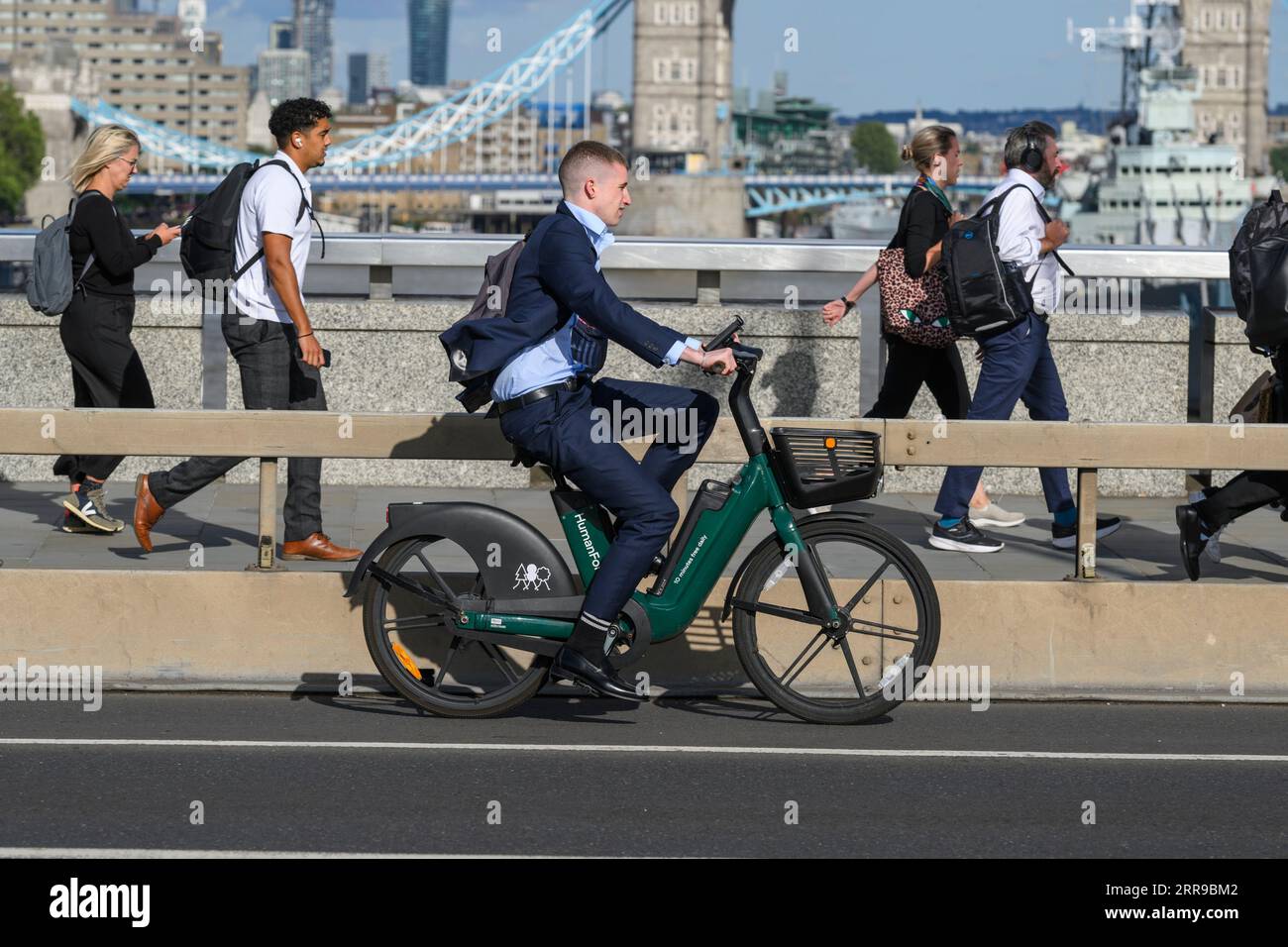 Un uomo che viaggia su una bicicletta elettrica HumanForest attraverso il London Bridge, durante l'ora di punta. London Bridge, Londra, Regno Unito. 17 luglio 2023 Foto Stock