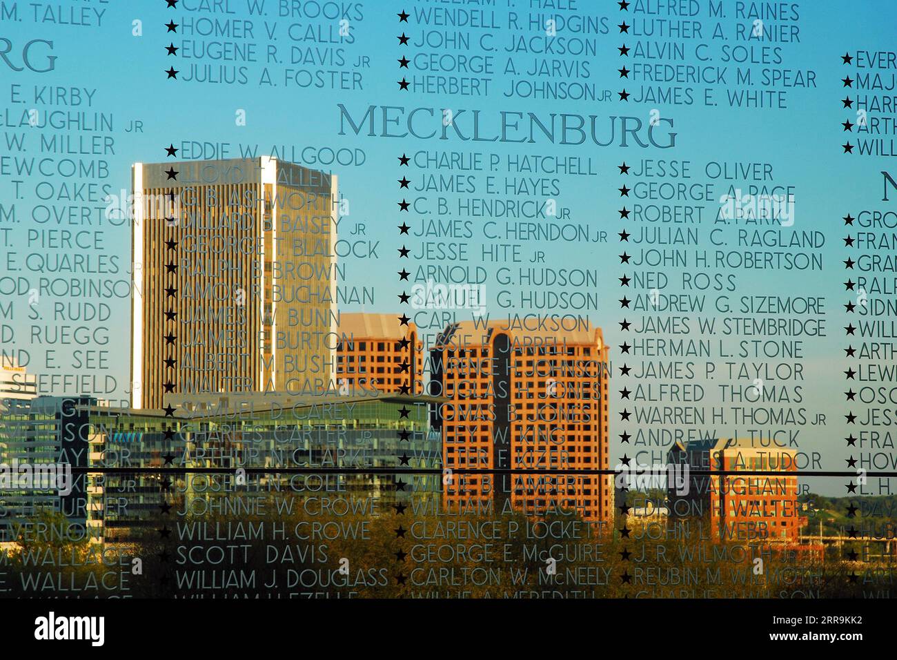 I nomi dei soldati della Virginia uccisi nella seconda guerra mondiale sono incisi in vetro, con dietro di esso lo skyline della città di Richmond Virginia Foto Stock