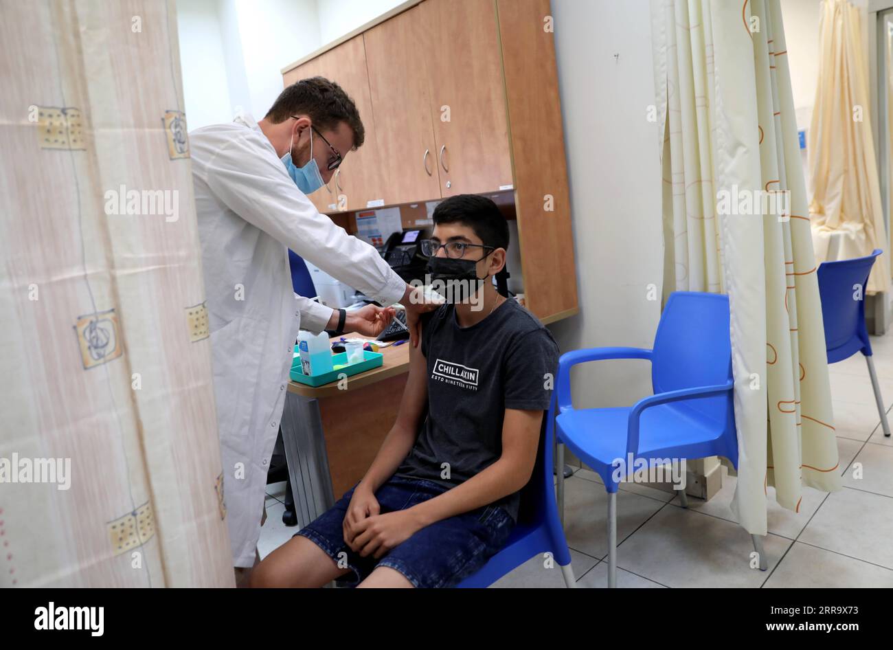 210705 -- MODIIN, 5 luglio 2021 -- un medico israeliano somministra una dose del vaccino anti COVID-19 a un ricevente in un centro di servizi sanitari a Modiin, Israele centrale, il 5 luglio 2021. L'efficacia del vaccino Pfizer contro il coronavirus è scesa a solo il 64% in Israele, ha detto il Ministero della salute del paese in una dichiarazione di lunedì. Foto di /Xinhua ISRAEL-MODIIN-COVID-19-VACCINATION GilxCohenxMagen PUBLICATIONxNOTxINxCHN Foto Stock