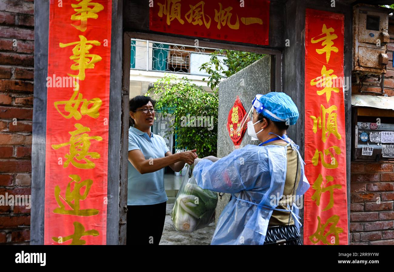 210708 -- RUILI, 8 luglio 2021 -- Un lavoratore della comunità basato sulla griglia consegna le necessità quotidiane a una famiglia sotto gestione chiusa nella città di Ruili, nella provincia dello Yunnan della Cina sud-occidentale, 8 luglio 2021. Ruili City mercoledì ha chiuso la sua città proprio e ha chiesto a tutti i residenti di sottoporsi a quarantena casa. La città, colpita da una recente rinascita COVID-19, ha affermato che le scuole sospenderanno le lezioni, i ristoranti saranno in grado di offrire solo servizi di asporto e tutti gli stabilimenti saranno chiusi ad eccezione di alcuni mercati, ospedali e farmacie. Il governo si assicurerà che le necessità siano fornite Foto Stock