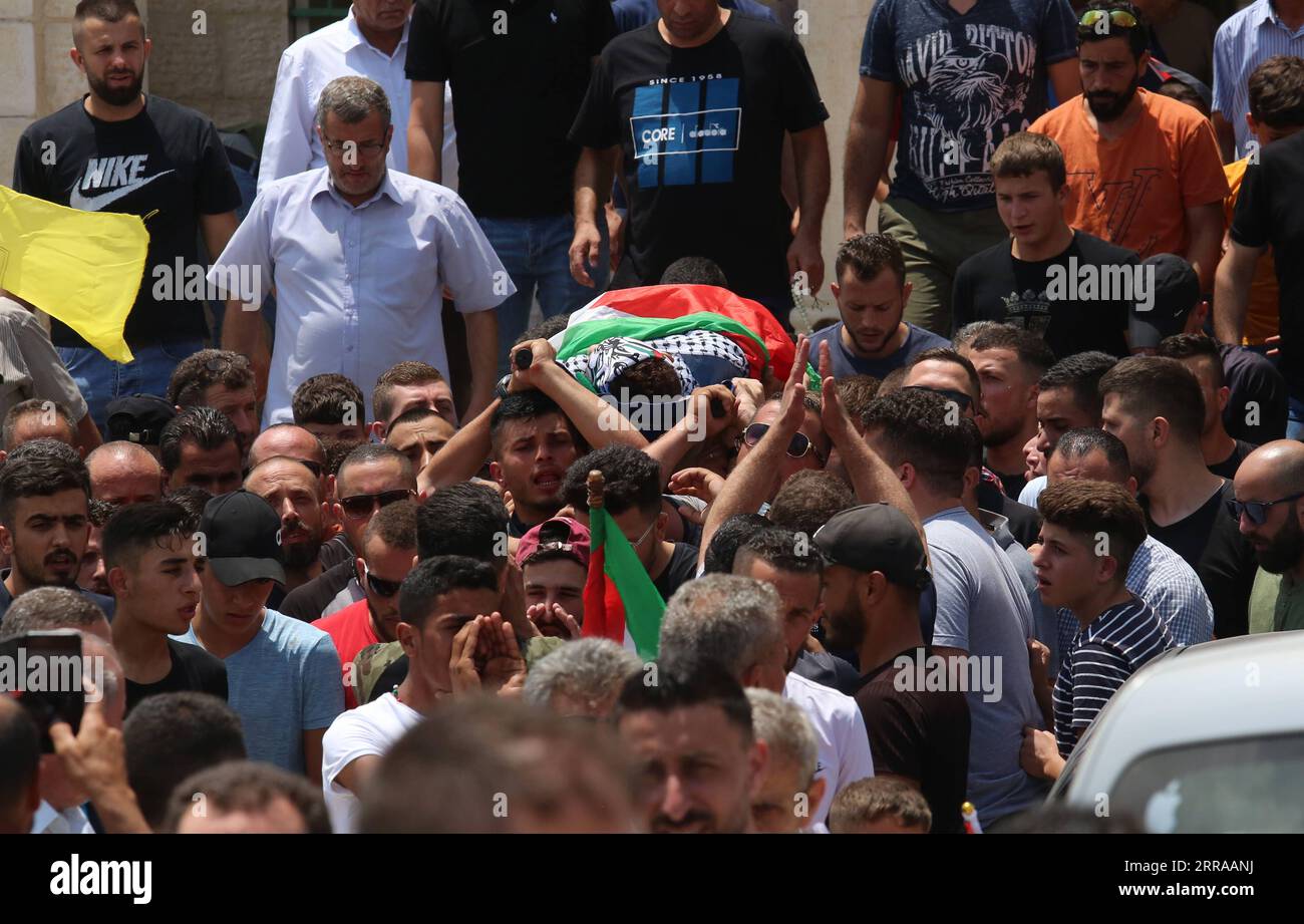 Westjordanland, Trauerfeier für Mohammed Tamimi in Ramallah 210724 -- RAMALLAH, 24 luglio 2021 -- lutti e parenti portano il corpo dell'adolescente palestinese Mohammed Tamimi durante il suo funerale nel villaggio di Deir Nizam, a ovest della città di Ramallah, 24 luglio 2021. Venerdì un adolescente palestinese è stato ucciso e decine di feriti negli scontri tra manifestanti palestinesi e soldati israeliani in Cisgiordania. Il ministero della salute palestinese ha dichiarato in una dichiarazione che Mohammed Tamimi, diciassettenne, è stato ucciso negli scontri nel villaggio di Nabi Saleh a nord-ovest della città di R Cisgiordania Foto Stock