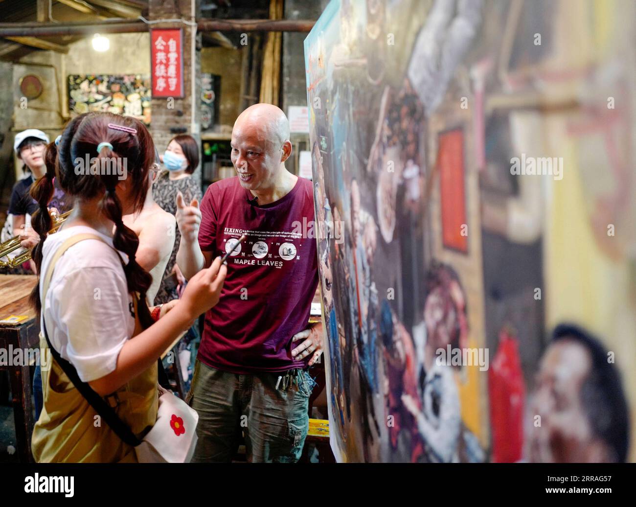 210730 -- CHONGQING, 30 luglio 2021 -- Chen Anjian 1st R parla con un cliente che è invitato a scarabocchiare sul suo dipinto ad olio al Communications Teahouse nel sud-ovest della Cina a Chongqing, 26 luglio 2021. Chen Anjian, 62 anni, insegnante di pittura ad olio presso l'Istituto di Belle Arti di Sichuan, frequenta la Chongqing Communications Teahouse da più di 20 anni. Fondata nel 1987, la Communications Teahouse è ora l'unica vecchia casa da tè di Chongqing che ha mantenuto lo stile originale degli anni '1970 e '80 E' uno dei punti di riferimento culturali chiave di Chongqing, ed e' visitato da migliaia di amanti del te' ogni giorno. Foto Stock