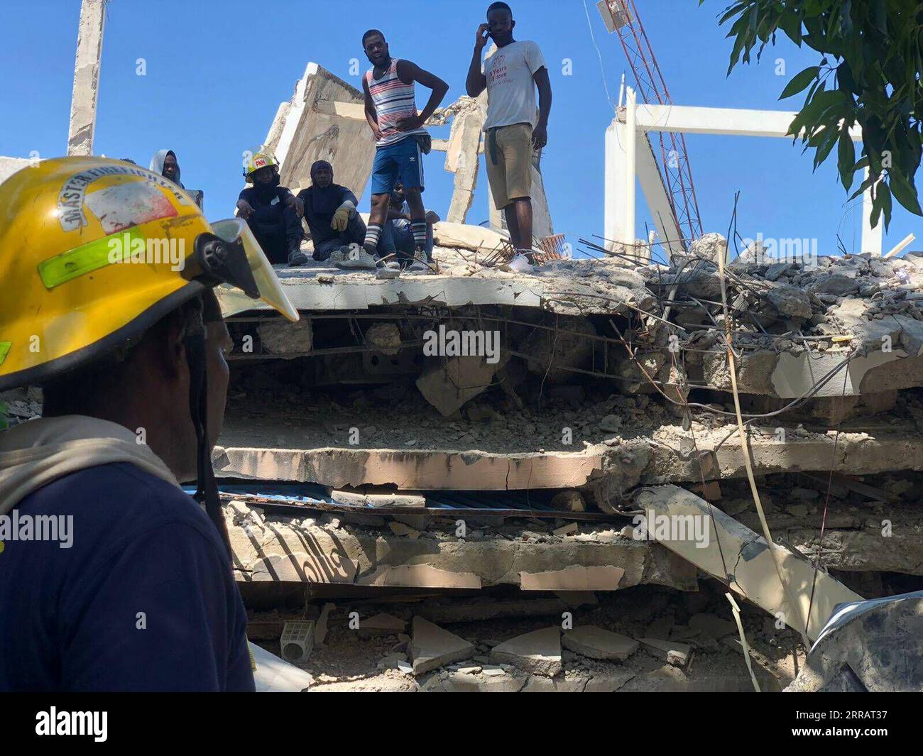 210815 -- LES CAYES, 15 agosto 2021 -- l'immagine scattata con un dispositivo mobile mostra le persone riunirsi in un edificio danneggiato dopo il terremoto a Les Cayes, Haiti, il 15 agosto 2021. Il bilancio delle vittime è salito a 724 in un forte terremoto che ha colpito Haiti sabato mattina, hanno dichiarato le autorità nazionali di protezione civile in una dichiarazione di domenica. Secondo i servizi di protezione civile di Haiti, finora sono stati registrati più di 2.800 feriti a causa del terremoto. Foto di /Xinhua HAITI-LES CAYES-TERREMOTO-NUMERO DI MORTI KatherinexHernandez PUBLICATIONxNOTxINxCHN Foto Stock