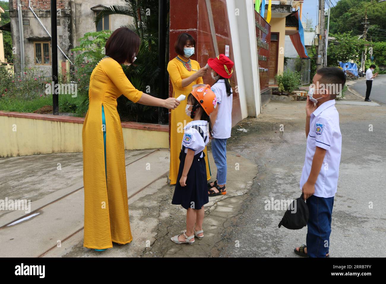 210905 -- HANOI, 5 settembre 2021 -- gli studenti delle scuole elementari hanno la temperatura presa prima di entrare a scuola nella provincia di Yen Bai del Vietnam settentrionale, 5 settembre 2021. Oltre due terzi delle 63 località a livello provinciale del Vietnam hanno iniziato il loro nuovo anno scolastico domenica in mezzo alla peggiore ondata di infezioni da COVID-19 del paese, ha riferito Vietnam News Agency. VNA via VIETNAM-SCHOOLS-OPENING Xinhua PUBLICATIONxNOTxINxCHN Foto Stock