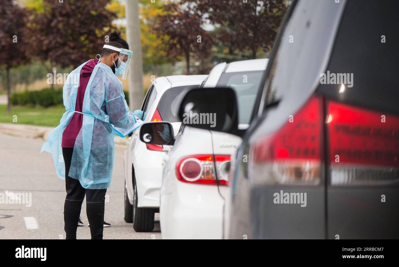 210914 -- MISSISSAUGA CANADA, 14 settembre 2021 -- Un operatore medico che indossa dispositivi di protezione individuale aiuta le persone a registrarsi fuori da un centro di test COVID-19 drive-thru a Mississauga, Ontario, Canada, il 14 settembre 2021. I casi cumulativi di COVID-19 del Canada hanno superato 1.550.000 a partire da martedì pomeriggio, con il totale che ha colpito 1.553.007, tra cui 27.252 morti, secondo CTV. Foto di /Xinhua CANADA-ONTARIO-MISSISSAUGA-COVID-19-CASES ZouxZheng PUBLICATIONxNOTxINxCHN Foto Stock