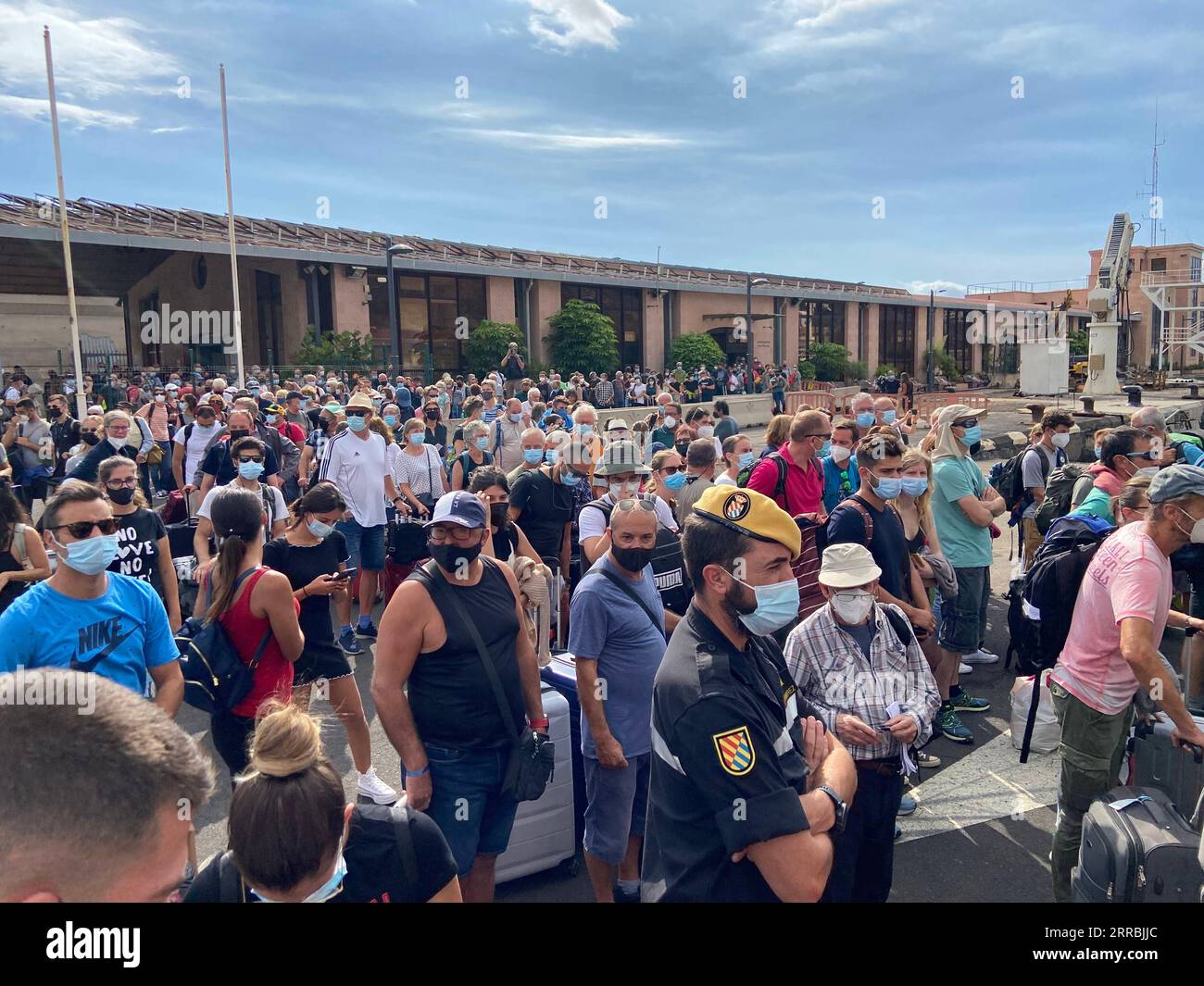 210926 -- LA PALMA, 26 settembre 2021 -- le persone aspettano di essere evacuate in un porto sull'isola di la Palma, in spagna, 25 settembre 2021. Con l'intensificata attività eruttiva del vulcano Cumbre Vieja sull'isola, le persone sull'isola di la Palma sono costrette ad essere evacuate. Dato che l'aeroporto locale è stato chiuso il 25 settembre, il servizio di traghetto rimane l'unico trasporto disponibile qui. SPAGNA-LA PALMA-ERUZIONE VULCANICA-EVACUAZIONE MENGXDINGBO PUBLICATIONXNOTXINXCHN Foto Stock