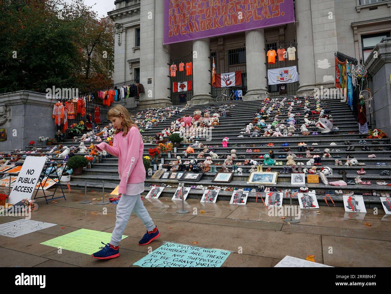 210930 -- VANCOUVER, 30 settembre 2021 -- Una ragazza passeggia accanto a giocattoli e scarpe in un evento commemorativo durante la prima giornata nazionale per la verità e la riconciliazione a Vancouver, British Columbia, Canada, il 30 settembre 2021. Il Canada ha celebrato la sua prima giornata nazionale per la verità e la riconciliazione giovedì per onorare i bambini perduti e i sopravvissuti del famigerato sistema scolastico residenziale indigeno del paese. Foto di /Xinhua CANADA-VANCOUVER-NATIONAL DAY FOR TRUTH AND RECONCILIATION LiangxSen PUBLICATIONxNOTxINxCHN Foto Stock