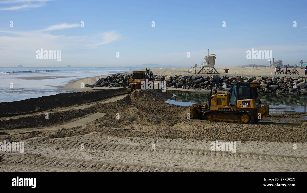 211004 -- CALIFORNIA, 4 ottobre 2021 -- i lavoratori guidano macchinari pesanti per costruire un berm per prevenire la fuoriuscita di petrolio nella Orange County, California, 3 ottobre 2021. Una massiccia fuoriuscita di petrolio al largo della costa della contea di Orange, nella California meridionale, ha portato alla chiusura di un'area di 9 chilometri di fronte alla spiaggia il 3 ottobre, e gli equipaggi del California Department of Fish and Wildlife CDFW stanno ripulendo l'inquinamento causato dalle strutture nelle acque federali. Foto di /Xinhua U.S.-CALIFORNIA-MASSICCIA FUORIUSCITA DI PETROLIO ZengxHui PUBLICATIONxNOTxINxCHN Foto Stock