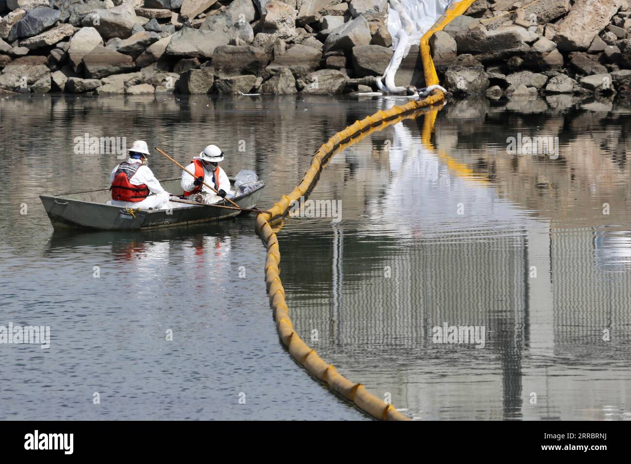 211005 -- LOS ANGELES, 5 ottobre 2021 -- i lavoratori raccolgono petrolio dall'acqua di mare a Huntington Beach, Orange County, California, Stati Uniti, 4 ottobre, 2021. una massiccia fuoriuscita di petrolio al largo della costa della contea di Orange, nella California meridionale, ha portato alla chiusura di un'area di 9 chilometri di fronte alla spiaggia domenica, e gli equipaggi del California Department of Fish and Wildlife CDFW stanno ripulendo l'inquinamento causato dalle strutture nelle acque federali. U.S.-CALIFORNIA-MASSICCE FUORIUSCITE DI OLIO PER LA PULIZIA DI GAOXSHAN PUBLICATIONXNOTXINXCHN Foto Stock
