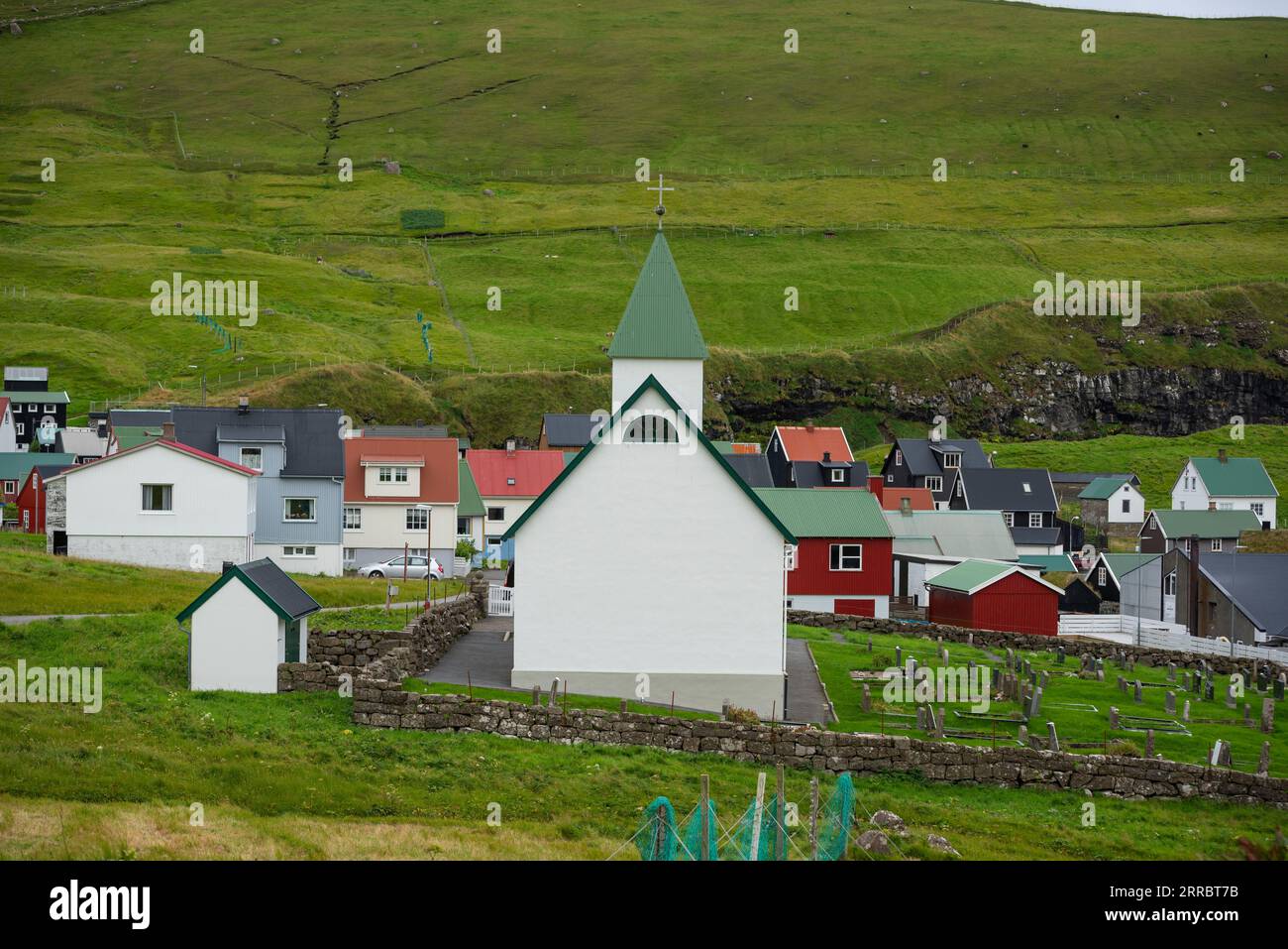 Il piccolo villaggio di Gjogv e la sua chiesa affollano il mare nell'angolo nord-est dell'isola di Eysturoy nelle Isole Faroe. Foto Stock