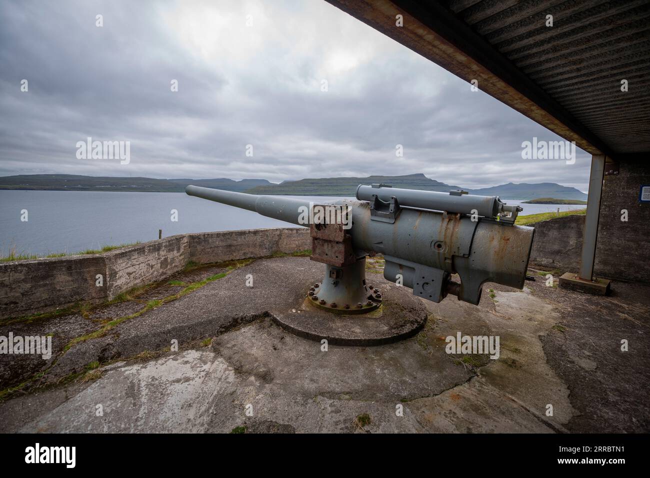 Un cannone britannico dell'era della seconda guerra mondiale per difendere Skalafirth al largo dell'isola di Eysturoy nelle Isole Faroe. Foto Stock