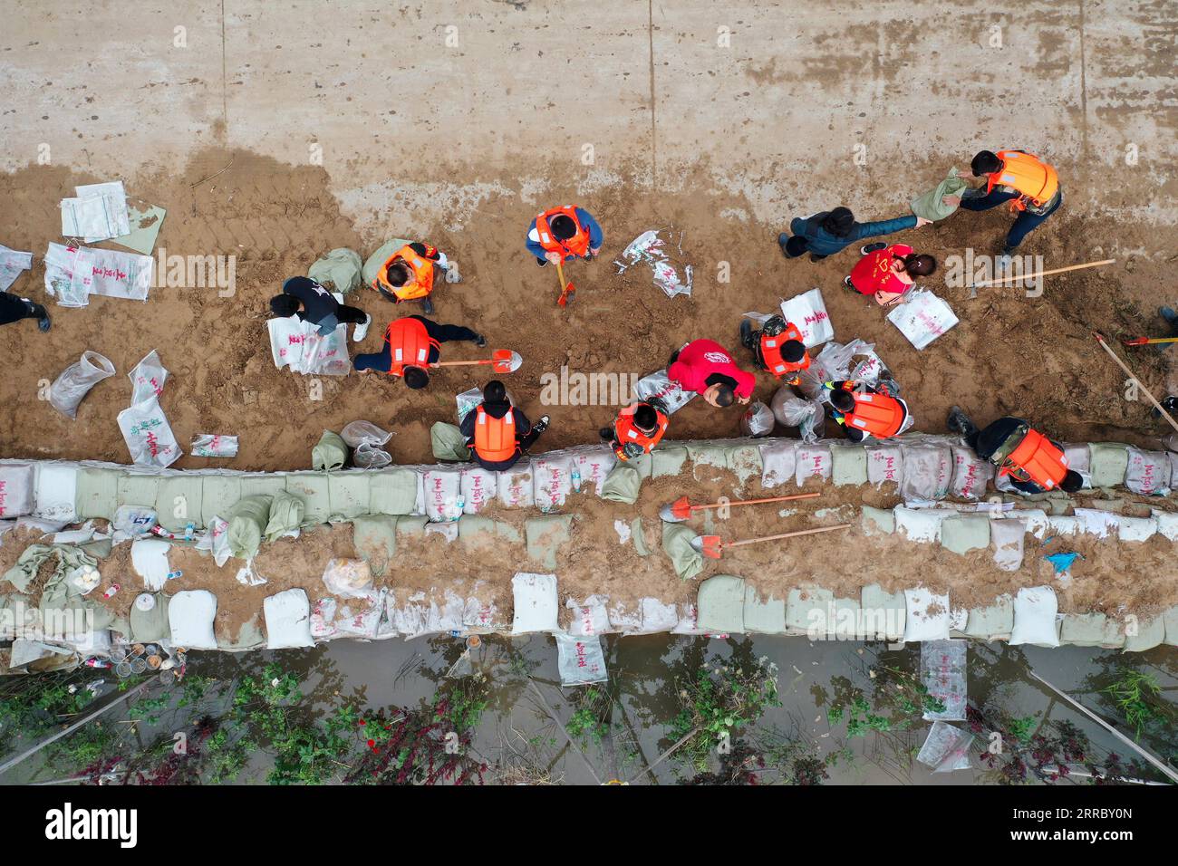 211010 -- HEJIN, 10 ottobre 2021 -- foto aerea mostra i soccorritori che fortificano la diga temporanea contro l'inondazione nel villaggio di Lianbo nella città di Hejin, nella provincia dello Shanxi della Cina settentrionale, 10 ottobre 2021. Più di 120.000 persone sono state temporaneamente evacuate dopo continue inondazioni innescate nella provincia dello Shanxi della Cina settentrionale, hanno detto domenica le autorità. Le inondazioni hanno sconvolto la vita di 1,76 milioni di residenti provenienti da 76 contee, città e distretti, secondo il dipartimento provinciale di gestione delle emergenze. Circa 190.000 ettari di colture furono danneggiati e più di 17.000 case crollarono, il de Foto Stock