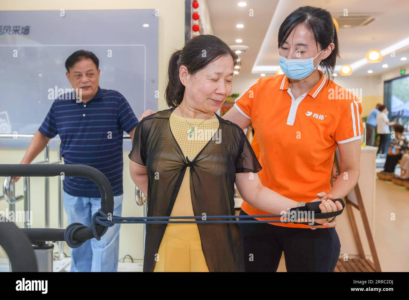 211014 -- SHANGHAI, 14 ottobre 2021 -- Un membro dello staff istruisce una signora anziana a svolgere un addestramento di stretching presso un centro di assistenza senior nel distretto di Xuhui di Shanghai, Cina orientale, 13 ottobre 2021. Chiamato Sports and Health Home for Elders , il centro di assistenza per anziani è un luogo polifunzionale per il fitness degli anziani. Fornisce agli anziani servizi one-stop come test di idoneità fisica, test di salute di base e guida scientifica di fitness, ecc.. CHINA-SHANGHAI-SENIOR CARE CENTER CN WANGXXIANG PUBLICATIONXNOTXINXCHN Foto Stock
