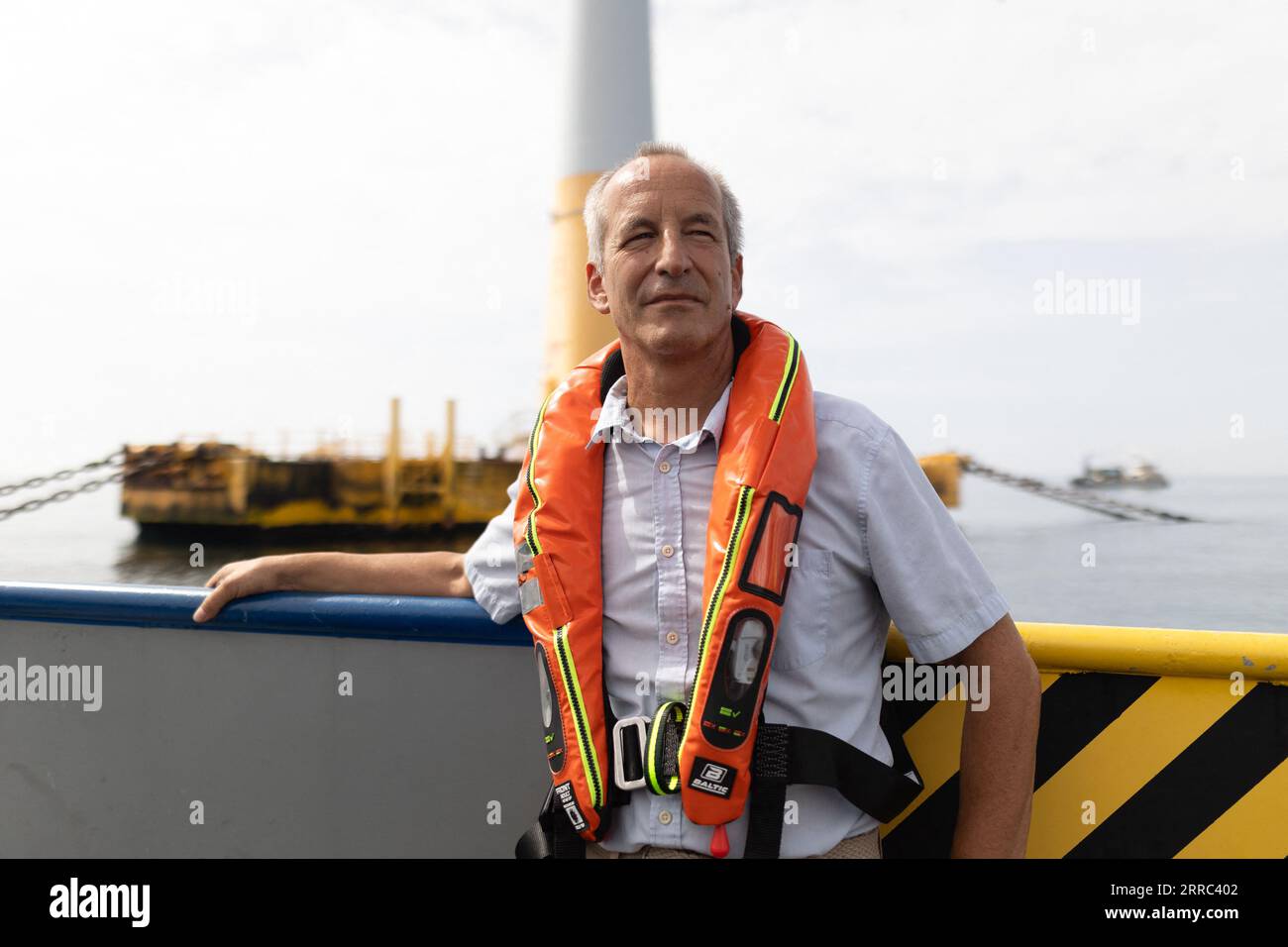 Le Croisic, Francia. 7 settembre 2023. Il direttore della Fondation apre C Bertrand Alessandrini su una barca accanto all'unità di produzione galleggiante di idrogeno Lhyfe accanto alla turbina eolica galleggiante Floatgen, presso il sito di sperimentazione SEM-Rev al largo di le Croisic, Francia occidentale, il 7 settembre 2023. Foto di Raphael Lafargue/ABACAPRESS.COM Credit: Abaca Press/Alamy Live News Foto Stock