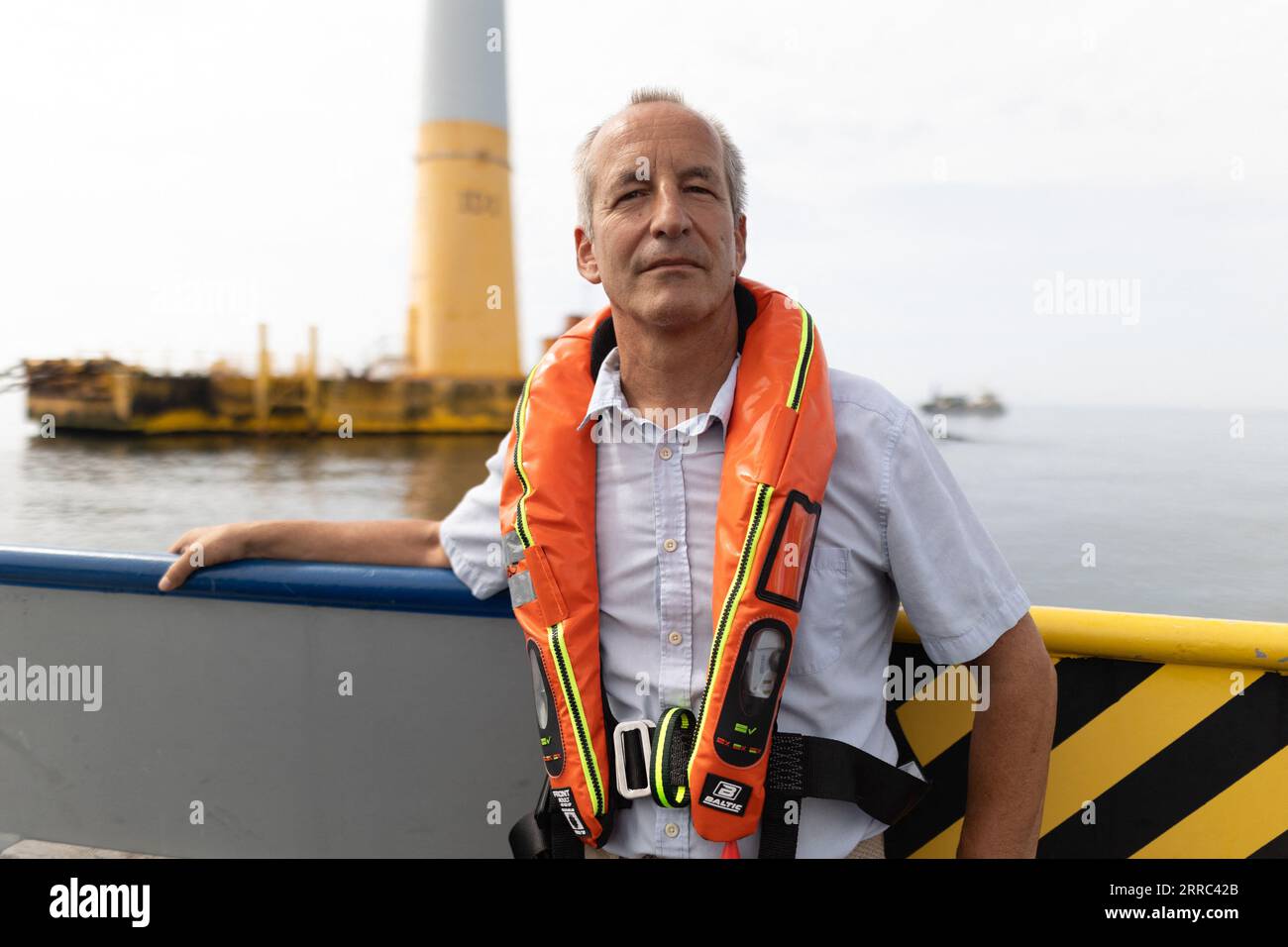 Le Croisic, Francia. 7 settembre 2023. Il direttore della Fondation apre C Bertrand Alessandrini su una barca accanto all'unità di produzione galleggiante di idrogeno Lhyfe accanto alla turbina eolica galleggiante Floatgen, presso il sito di sperimentazione SEM-Rev al largo di le Croisic, Francia occidentale, il 7 settembre 2023. Foto di Raphael Lafargue/ABACAPRESS.COM Credit: Abaca Press/Alamy Live News Foto Stock