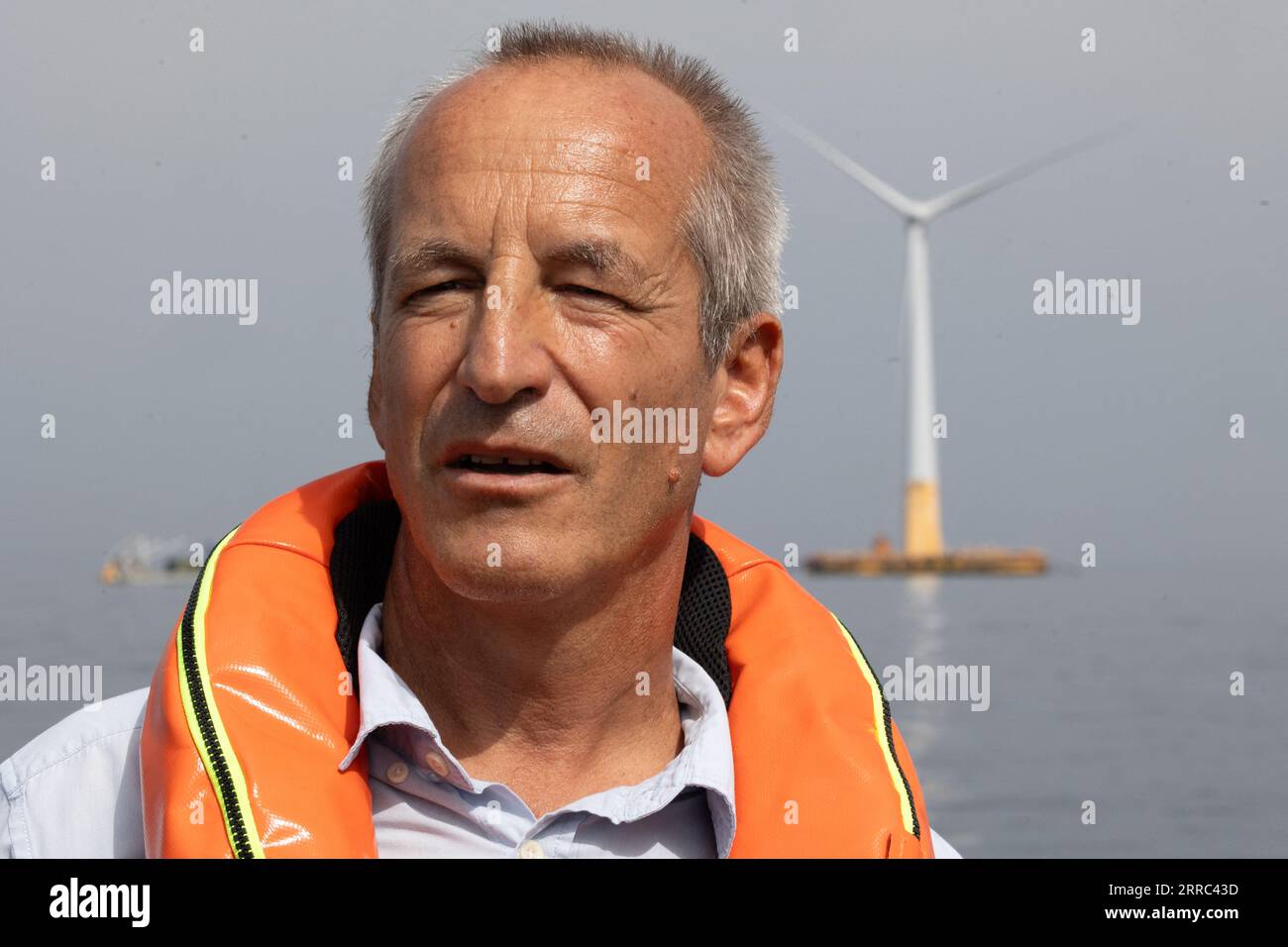Le Croisic, Francia. 7 settembre 2023. Il direttore della Fondation apre C Bertrand Alessandrini su una barca accanto all'unità di produzione galleggiante di idrogeno Lhyfe accanto alla turbina eolica galleggiante Floatgen, presso il sito di sperimentazione SEM-Rev al largo di le Croisic, Francia occidentale, il 7 settembre 2023. Foto di Raphael Lafargue/ABACAPRESS.COM Credit: Abaca Press/Alamy Live News Foto Stock
