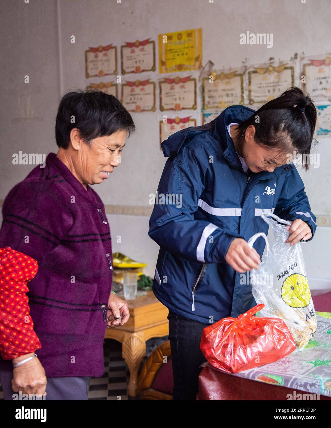 211104 -- LEIYANG, 4 novembre 2021 -- Hu Xia R raccoglie i pacchi nel villaggio Jinping di Huangshi Town a Leiyang, nella provincia di Hunan, nella Cina centrale, 3 novembre 2021. HU Xia è una deliverywoman post-90 che fornisce servizio di consegna per quattro villaggi nella città di Huangshi. Negli ultimi sette anni, il numero di ordini di consegna locali nelle zone rurali è aumentato da meno di 10 al giorno a più di 200. Oltre alla consegna dei pacchetti, Hu aiuta anche gli abitanti del villaggio a vendere germogli di bambù, uova e altre specialità agricole attraverso il negozio online. La sua stazione di consegna è diventata uno dei luoghi più vivaci del villaggio. Foto Stock