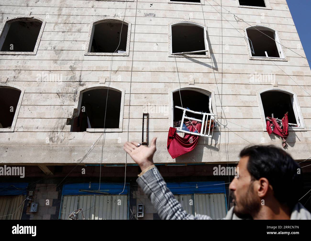 211111 -- SANAA, 11 novembre 2021 -- Un residente locale punti alle finestre rotte di un edificio che è stato danneggiato durante un attacco aereo in un quartiere di Sanaa, Yemen, l'11 novembre 2021. Gli aerei da guerra della coalizione guidata dai sauditi hanno lanciato attacchi aerei multipli su campi militari controllati dalla milizia Houthi nella capitale dello Yemen Sanaa e intorno a essa, giovedì mattina presto, ha riferito al TV al-Masirah, gestita da Houthi. Foto di /Xinhua YEMEN-SANAA-AIRSTRIKES MohammedxMohammed PUBLICATIONxNOTxINxCHN Foto Stock