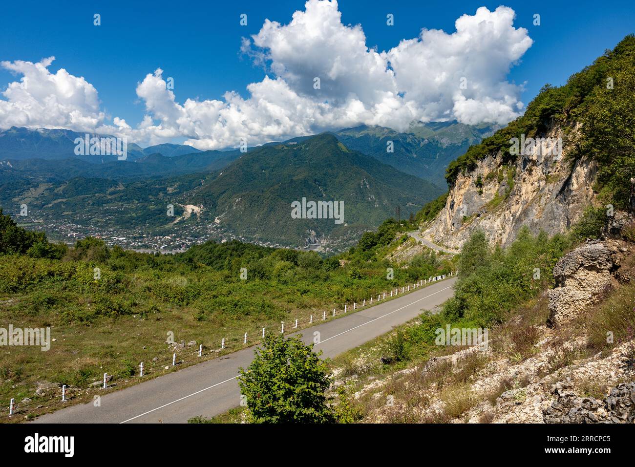 Strada asfaltata di montagna con belle nuvole di cumulus Foto Stock