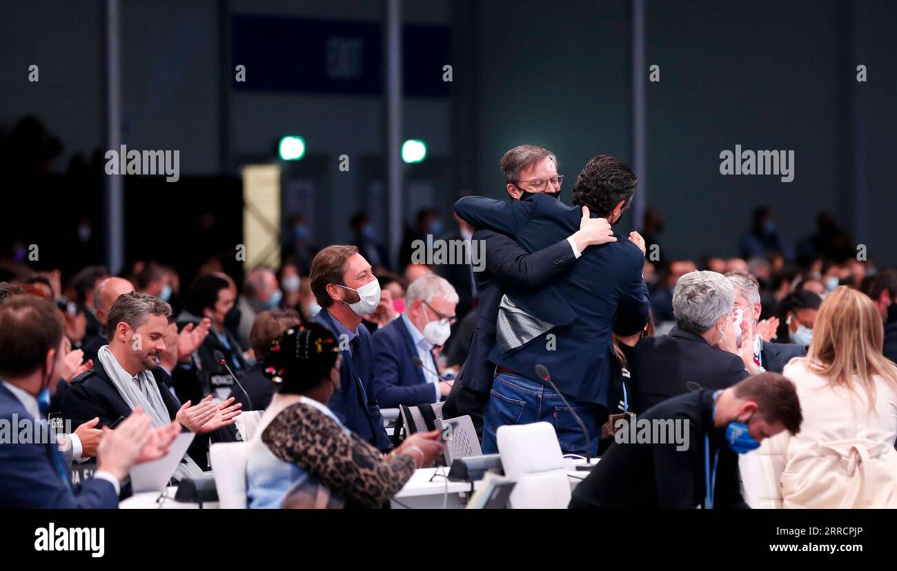 211114 -- GLASGOW, 14 novembre 2021 -- due delegati si abbracciano a vicenda durante la sessione plenaria conclusiva della 26a sessione della Conferenza delle parti COP26 della Convenzione quadro delle Nazioni Unite sui cambiamenti climatici a Glasgow, Regno Unito, 13 novembre 2021. La conferenza delle Nazioni Unite sul cambiamento climatico si è conclusa qui sabato dopo una proroga di un giorno, con i negoziatori che hanno concordato un nuovo patto globale per affrontare il cambiamento climatico. UK-GLASGOW-COP26-CONCLUSION HanxYan PUBLICATIONxNOTxINxCHN Foto Stock