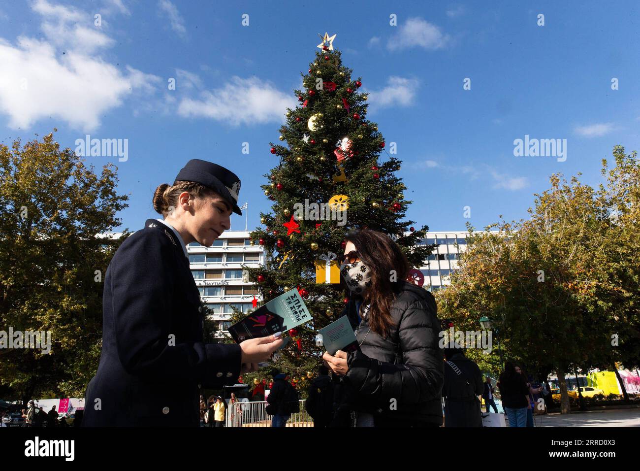 211126 -- ATENE, 26 novembre 2021 -- Una poliziotta dà volantini ai passanti nella giornata internazionale per l'eliminazione della violenza contro le donne ad Atene, Grecia, 25 novembre 2021. GRECIA-ATENE-GIORNATA INTERNAZIONALE PER L'ELIMINAZIONE DELLA VIOLENZA CONTRO LE DONNE MARIOSXLOLOS PUBLICATIONXNOTXINXCHN Foto Stock