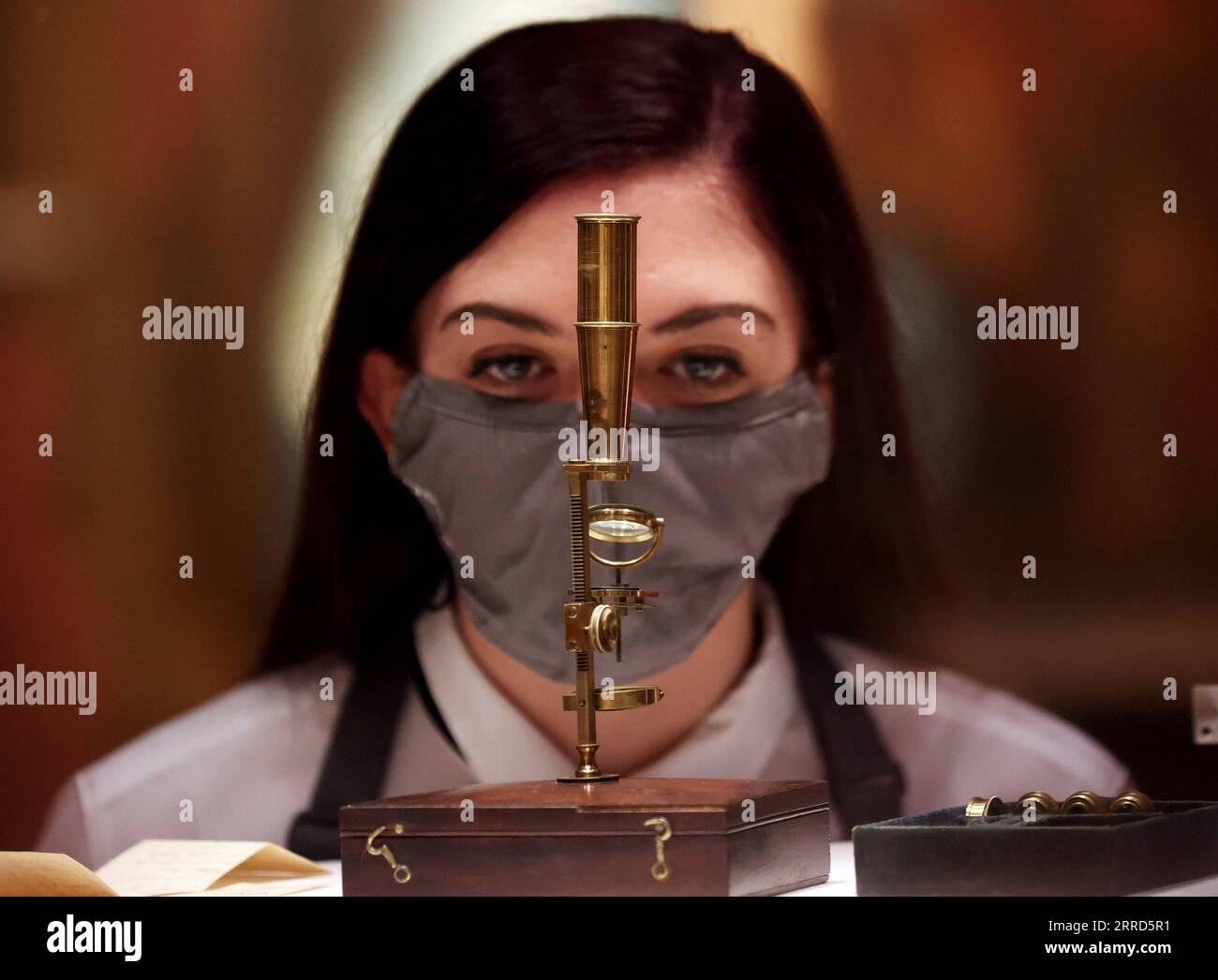 211204 -- LONDRA, 4 dicembre 2021 -- Un membro dello staff controlla il Charles Darwin Family Microscope per l'asta durante un'anteprima mediatica dell'asta Christie's London Classic Week a Londra, Gran Bretagna, 3 dicembre 2021. La Christie's London Classic Week presenta arte dall'antichità al XXI secolo, con cinque aste dal vivo e quattro vendite solo online. BRITAIN-LONDON-CHRISTIE S-AUCTION-PREVIEW LIXYING PUBLICATIONXNOTXINXCHN Foto Stock