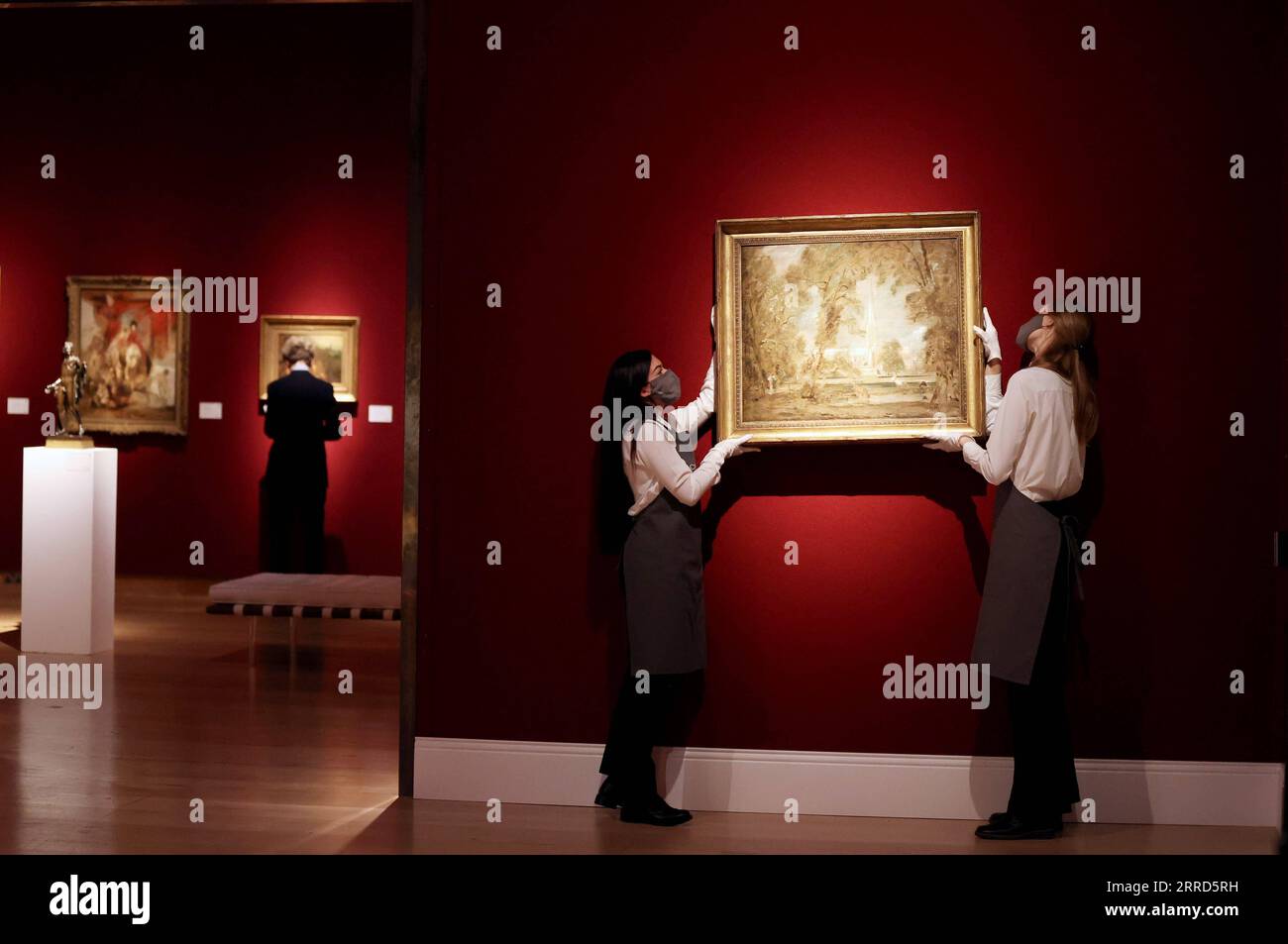 211204 -- LONDRA, 4 dicembre 2021 -- due membri dello staff appendono un'opera d'arte sul muro durante un'anteprima mediatica dell'asta Christie's London Classic Week a Londra, Gran Bretagna, 3 dicembre 2021. La Christie's London Classic Week presenta arte dall'antichità al XXI secolo, con cinque aste dal vivo e quattro vendite solo online. BRITAIN-LONDON-CHRISTIE S-AUCTION-PREVIEW LIXYING PUBLICATIONXNOTXINXCHN Foto Stock