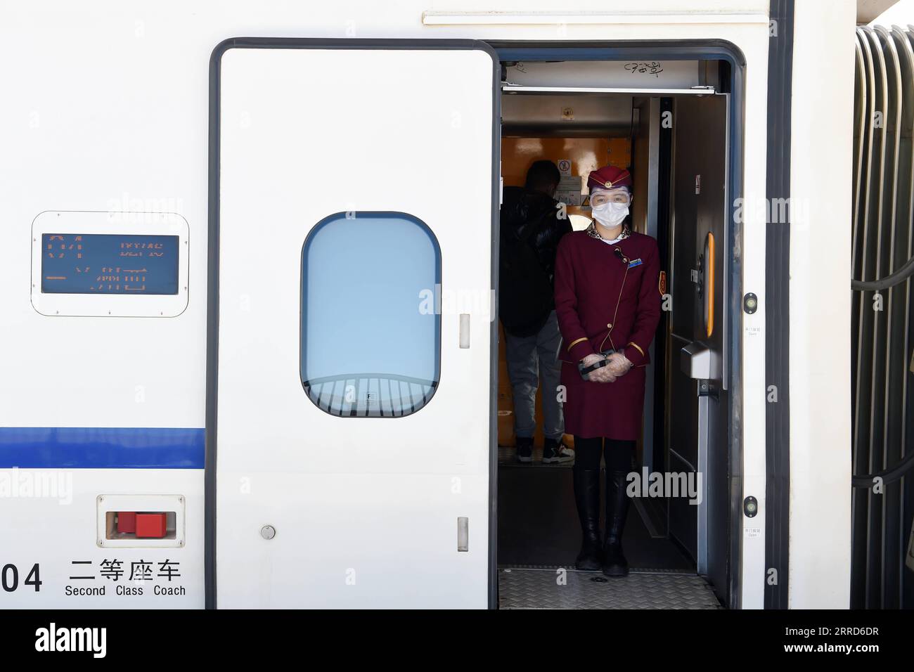 211205 -- ZHANGYE, 5 dicembre 2021 -- Una hostess è vista in servizio su un treno proiettile alla stazione ferroviaria Shandan Horse Ranch della ferrovia Lanzhou-Xinjiang nella contea di Shandan, Zhangye City, provincia del Gansu della Cina nord-occidentale, 5 dicembre 2021. La stazione ferroviaria Shandan Horse Ranch, ad un'altitudine di oltre 3.000 metri, ha iniziato a funzionare domenica. I treni proiettile, che possono portare passeggeri a Lanzhou, Xi An, Urumqi, Jiayuguan e Dunhuang, entreranno in stazione ogni giorno. La ferrovia Lanzhou-Xinjiang collega la provincia di Gansu della Cina nord-occidentale e la regione autonoma di Uygur dello Xinjiang. Situato nel Qil Foto Stock