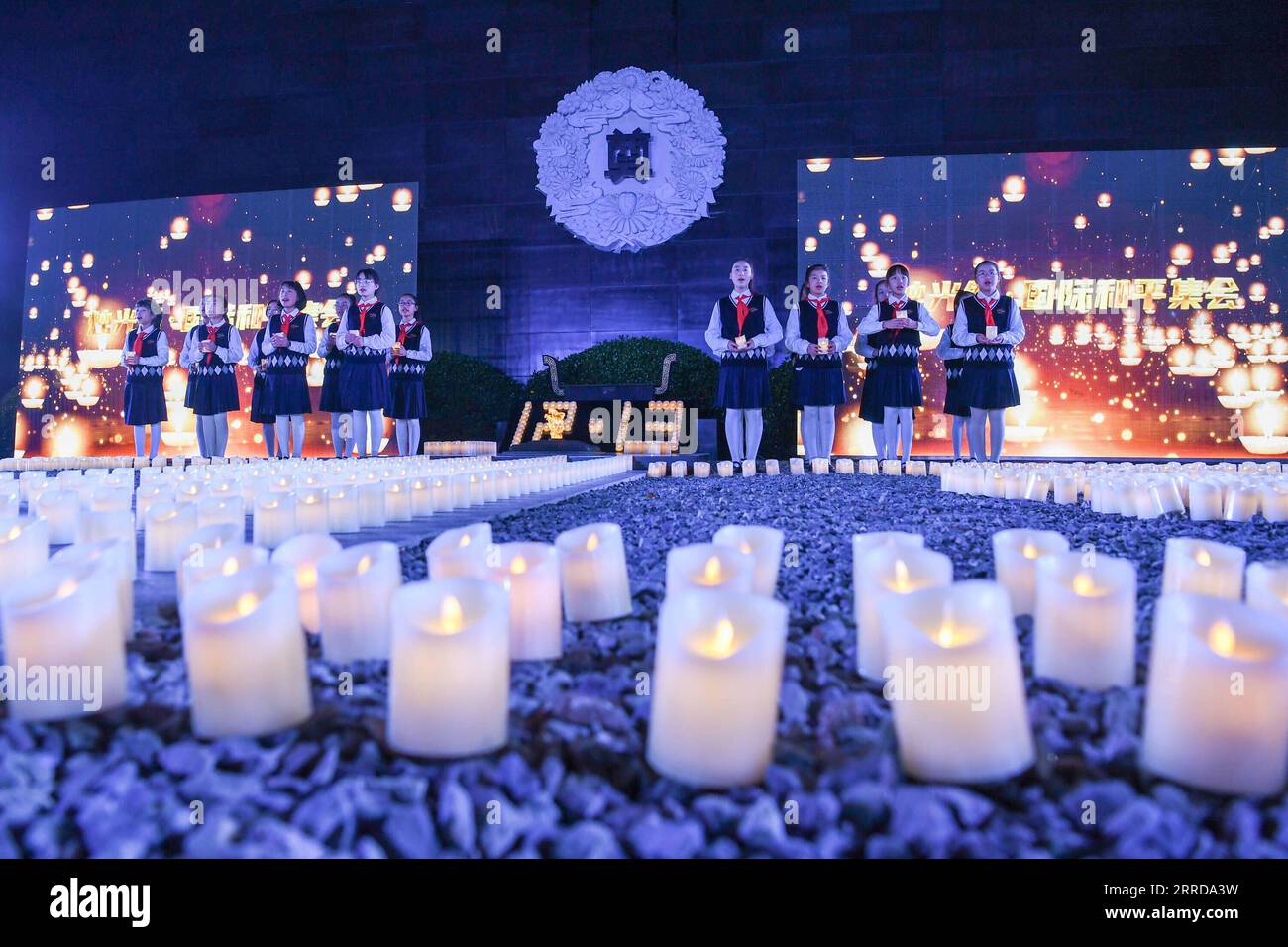 211213 -- NANCHINO, 13 dicembre 2021 -- gli studenti prendono parte a una veglia a lume di candela in commemorazione delle vittime del massacro di Nanchino in occasione dell'ottavo giorno della memoria nazionale presso la sala commemorativa delle vittime del massacro di Nanchino da parte degli invasori giapponesi a Nanchino, capitale della provincia del Jiangsu della Cina orientale, 13 dicembre 2021. Il massacro di Nanchino ebbe luogo dopo che le truppe giapponesi conquistarono la città il 13 dicembre 1937. Nel corso di sei settimane, uccisero circa 300.000 civili cinesi e soldati disarmati in uno degli episodi più barbarici della seconda guerra mondiale CINA-NANCHINO MASSACRO COMMEMORAZIONE C. Foto Stock