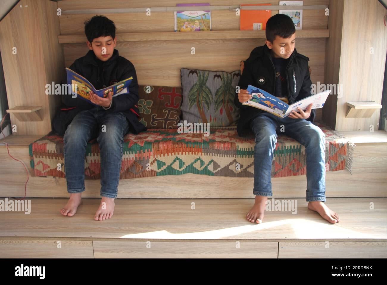 211216 -- KABUL, 16 dicembre 2021 -- i bambini leggono libri di cartoni animati in una biblioteca mobile a Kabul, capitale dell'Afghanistan, 14 dicembre 2021. Ispirato da un gruppo di giovani afghani, un gruppo di beneficenza locale fornisce servizi di biblioteca mobile gratuiti ai bambini in Kabul devastata dalla guerra. PER ANDARE CON caratteristiche: La biblioteca pubblica afghana si sforza di fornire un libro per tutti in mezzo a una guerra prolungata foto di /Xinhua AFGHANISTAN-KABUL-MOBILE BIBLIOTECA SaifurahmanxSafi PUBLICATIONxNOTxINxCHN Foto Stock