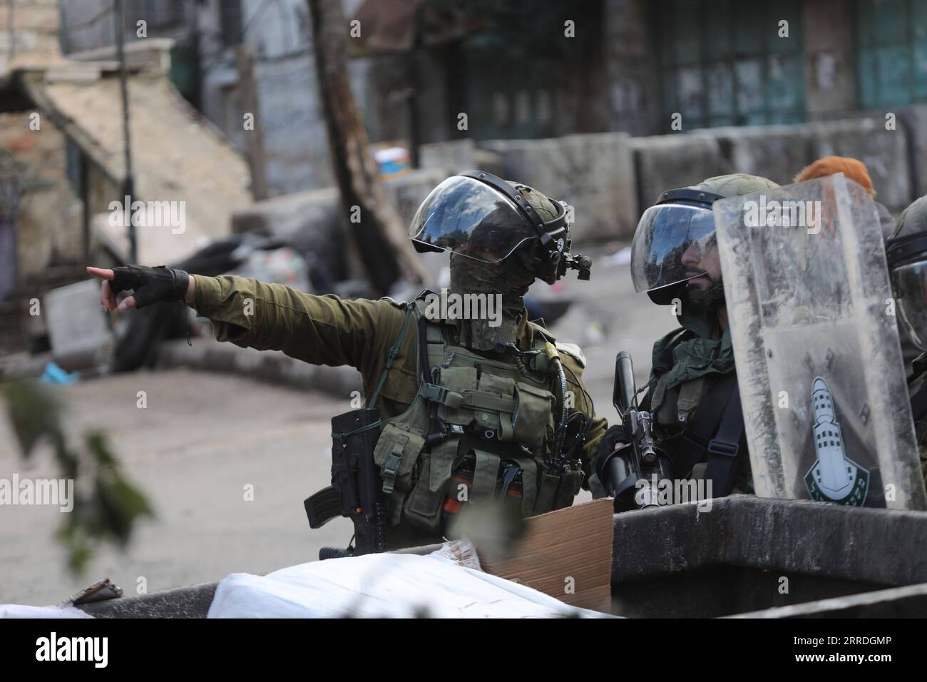 211224 -- HEBRON, 24 dicembre 2021 -- i soldati israeliani detengono le armi durante gli scontri con manifestanti palestinesi a seguito di una protesta contro l'espansione degli insediamenti ebraici e contro le pratiche dei servizi carcerari israeliani contro le donne palestinesi detenute nelle prigioni israeliane, nella città di Hebron, 24 dicembre 2021. Foto di /Xinhua MIDEAST-HEBRON-CLASHES MamounxWazwaz PUBLICATIONxNOTxINxCHN Foto Stock