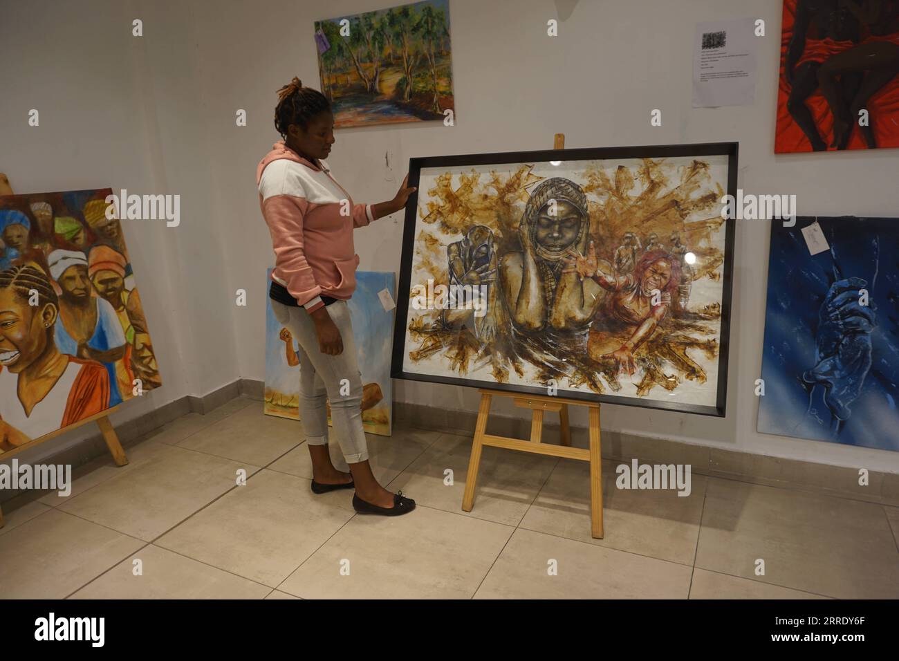 220113 -- LUSAKA, 13 gennaio 2022 -- Una donna vede un dipinto alla Twice Art Gallery di Lusaka, Zambia, l'8 gennaio 2022. IN PRIMO piano: La galleria d'arte zambiana attira notevole interesse nonostante i guai economici COVID-19 foto di /Xinhua ZAMBIA-LUSAKA-ART GALLERY LillianxBanda PUBLICATIONxNOTxINxCHN Foto Stock