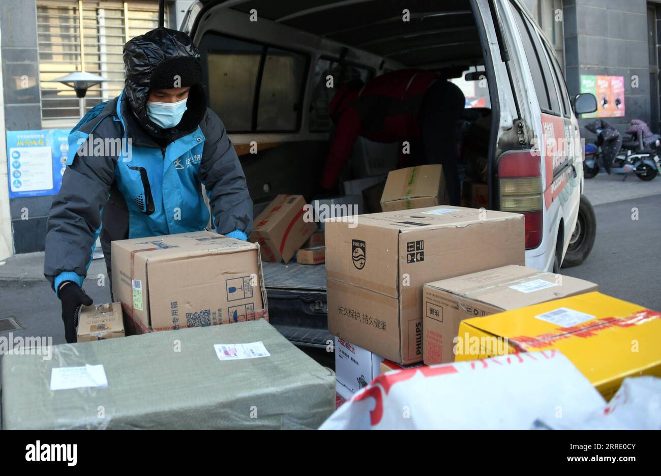 220116 -- PECHINO, 16 gennaio 2022 -- Un corriere organizza pacchi da consegnare ai residenti in un complesso residenziale nel distretto di Haidian di Pechino, capitale della Cina, 16 gennaio 2022. Pechino ha riferito un nuovo caso di COVID-19 trasmesso localmente sabato, l'autorità sanitaria locale ha detto. La comunità in cui vive il caso confermato è sotto la gestione ravvicinata. CHINA-BEIJING-COVID-19-CONTROLLO E PREVENZIONE CN RENXCHAO PUBLICATIONXNOTXINXCHN Foto Stock