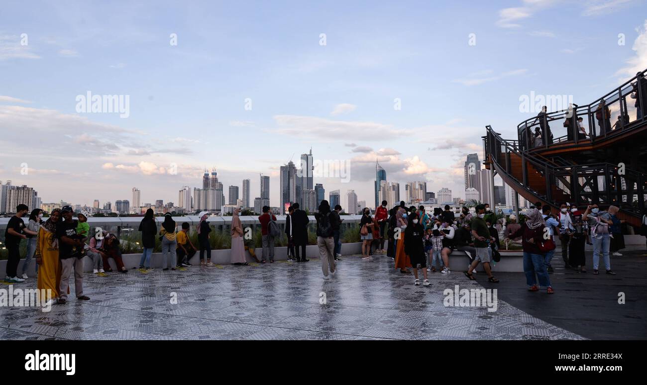 220123 -- GIACARTA, 23 gennaio 2022 -- la gente gode di una vista sulla città vicino allo Skywalk del Senayan Park a Giacarta, Indonesia, 23 gennaio 2022. Il 18 gennaio i legislatori indonesiani hanno approvato una legge sul trasferimento della capitale della nazione sull'isola di Kalimantan, che il paese confina con la Malesia e il Brunei, dall'isola più popolata di Giava. Nusantara, che la nuova capitale è chiamata, sarà costruita in due distretti del Kalimantan orientale: Penajam Paser Utara e Kutai Kartanegara. Si prevede che occuperà circa 256.000 ettari di terreno. Nusantara servirà come centro del governo, mentre Giacarta Foto Stock