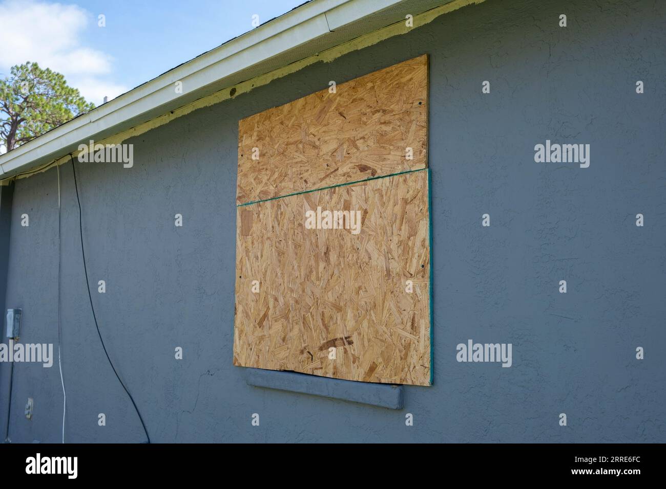 Persiane Hurricane realizzate in compensato montate per la protezione delle finestre delle abitazioni. Misure protettive prima del disastro naturale in Florida Foto Stock