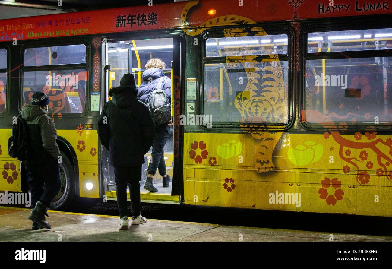 220208 -- TORONTO, 8 febbraio 2022 -- i passeggeri salgono su un autobus con un design che celebra il Capodanno lunare della Tigre in una stazione degli autobus di Toronto, Canada, 7 febbraio 2022. Il Toronto Transit Commission TTC ha partecipato alla celebrazione del nuovo anno lunare avvolgendo una serie di veicoli che erano stati programmati per essere in servizio dal 1° al 15 febbraio di quest'anno. Foto di /Xinhua CANADA-TORONTO-TTC-LUNAR CELEBRAZIONE DEL NUOVO ANNO ZouxZheng PUBLICATIONxNOTxINxCHN Foto Stock