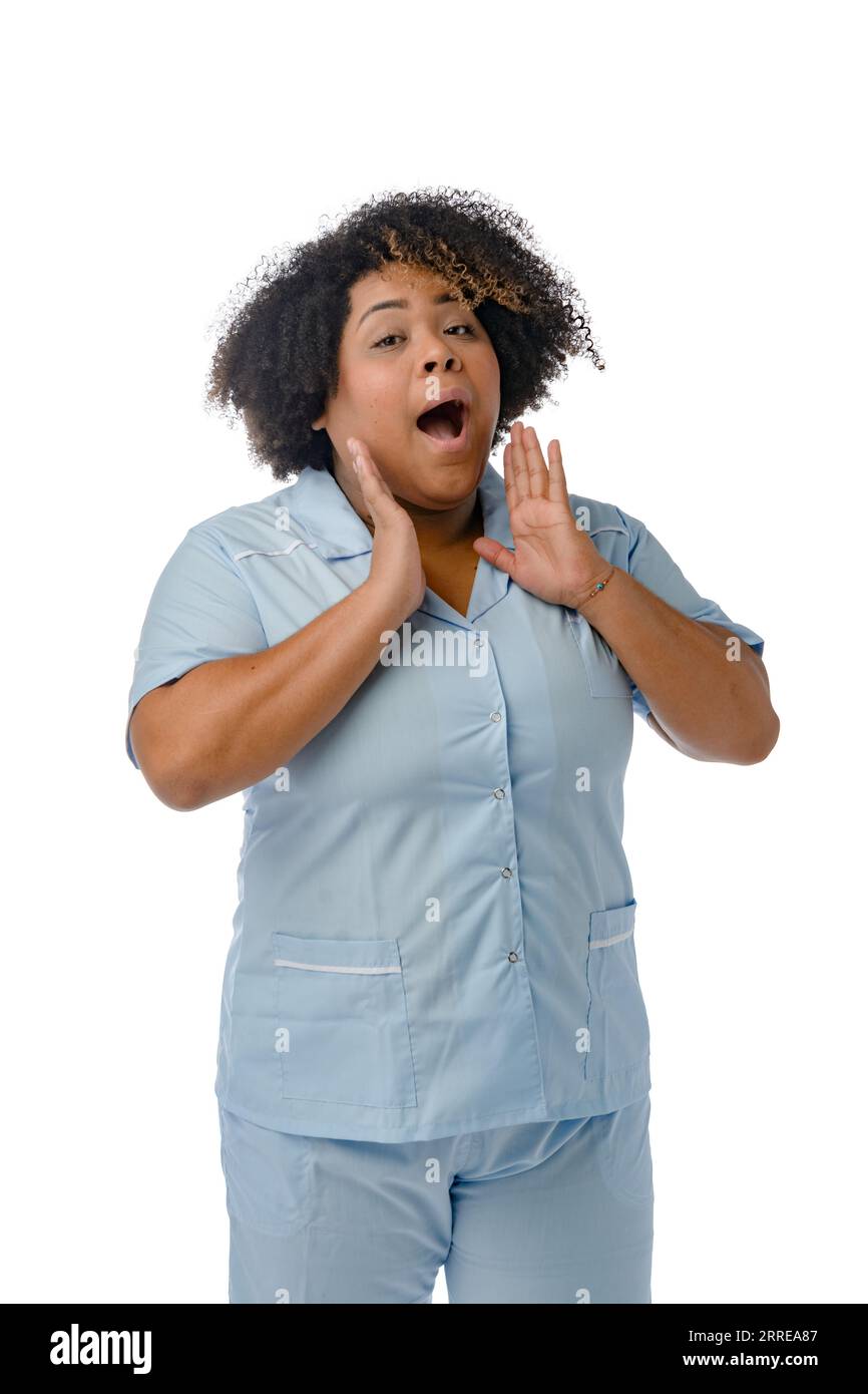 ritratto verticale di una donna venezuelana afro latina in uniforme blu, in piedi con le mani sul viso e a bocca aperta urlando e guardando la macchina fotografica, Foto Stock