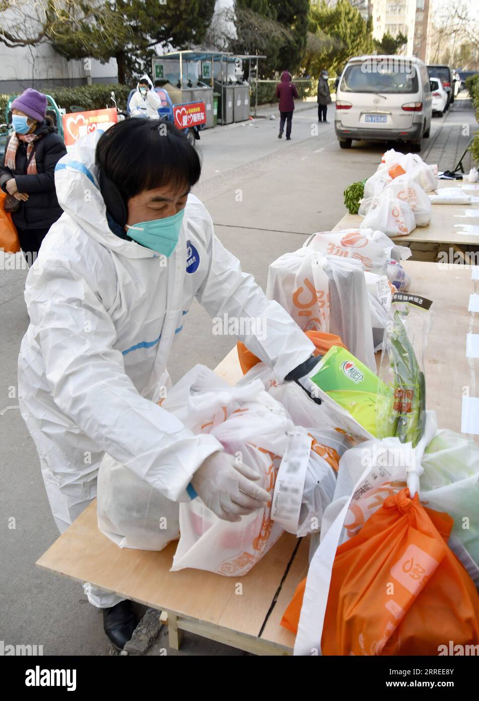 220223 -- PECHINO, 23 febbraio 2022 -- Un membro del personale riceve articoli di consegna espressa e ordini di cibo per i residenti in un complesso residenziale nel distretto di Fengtai a Pechino, capitale della Cina, 23 febbraio 2022. Pechino ha riportato otto casi confermati di COVID-19 trasmessi localmente dalle 11:00 martedì alle 11:00 mercoledì, le autorità locali hanno detto mercoledì. I casi provengono dall'area di sviluppo economico-tecnologico di Pechino, dal distretto di Chaoyang, dal distretto di Tongzhou, dal distretto di Shunyi e dal distretto di Xicheng, secondo un comunicato stampa tenuto dal governo municipale. CHINA-BEIJING-COVID-19-MISURA CN LIX Foto Stock